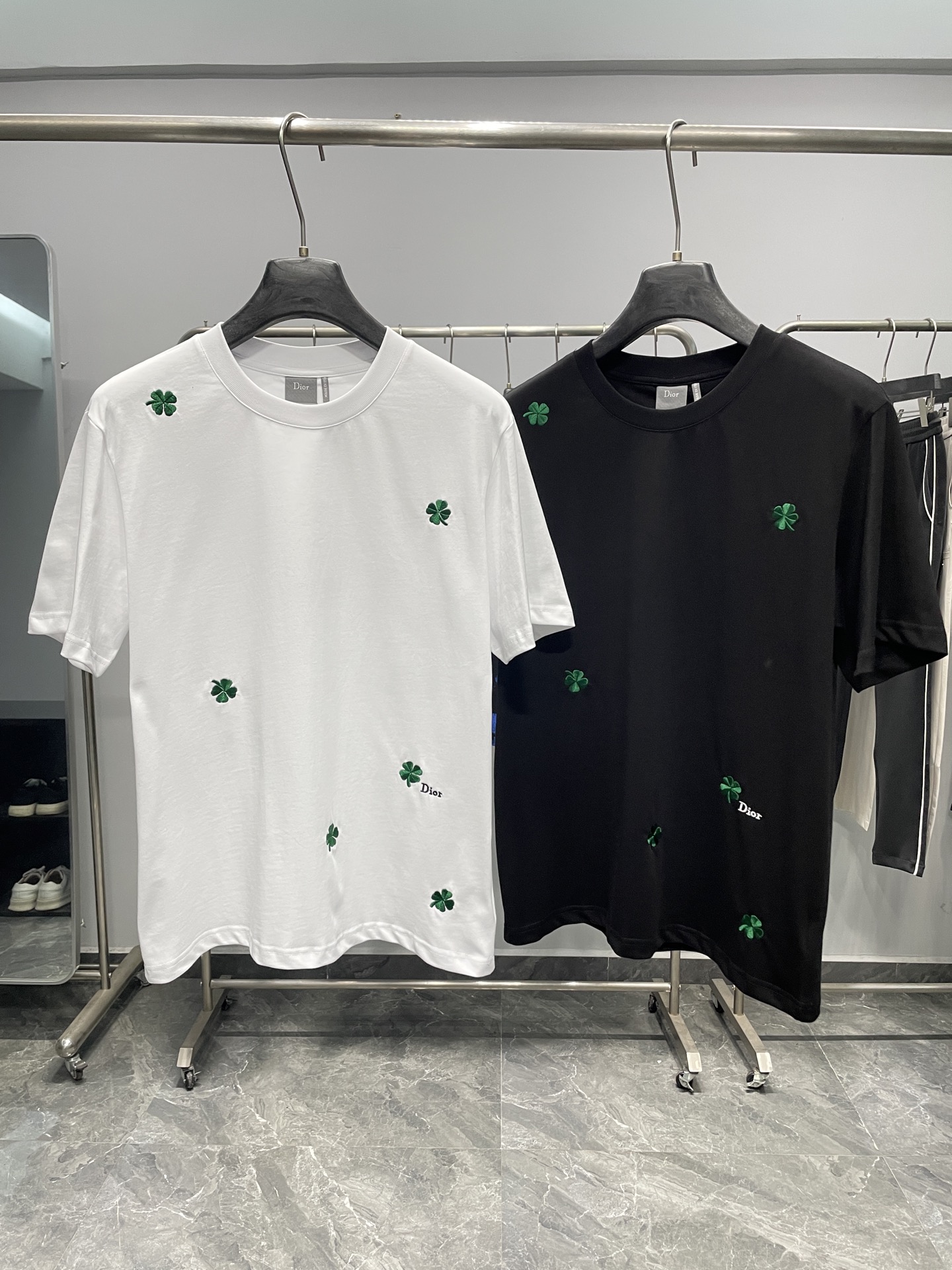 NO:777707,CD26SS new spring and summer new jersey cotton basic round neck short T-shirt, same style for men and women, casual short-sleeved T-shirt with full green four-leaf clover pattern embroidery!  The trading company channel is rare, and it is available for sale on the official website simultaneously for 12,405RMB!  On the fashion stage, new trend elements appear every season, and this four-leaf clover embroidered T-shirt from D is undoubtedly the most dazzling star in early spring. With its unique design and excellent quality, it attracts the attention of countless fashion lovers!  This T-shirt is made of custom-made plain knitted cotton fabric. The fabric adopts advanced plain knitting technology, which makes the texture of the cloth fine and even, without any rough feeling!  When you gently touch this T-shirt, it feels like you are touching clouds. The skin-friendly and comfortable feeling spreads throughout your body instantly. It can give you the gentlest care, allowing you to forget all your worries and enjoy your comfortable time!  The green four-leaf clover pattern embroidery on the T-shirt is the soul of this dress!  The whole body is embellished with exquisite green four-leaf clover pattern embroidery, and each leaf is lifelike, as if it is an elf given by nature, with the breath of spring and vitality!  The embroidery craftsmanship is even more exquisite, the stitching is delicate and even, the lines are smooth and natural, and the shape of the four-leaf clover is perfectly presented!  Under the sunlight, the green silk threads shine softly, as if telling the story of spring!  When you put on this T-shirt, you feel like you are wearing the whole spring on your body, giving you a spring fashion effect!  Fitted and cut, it can well show the wearer's figure advantages. Whether it is a slim figure or a plump figure, it will look more charming against the backdrop of this T-shirt!  Color White, Black Size S-XXL Size Reference S Size Shoulder Width 45 Bust Length 67 M Size Shoulder Width 46 Bust 104 Length 68 L Size Shoulder Width 47 Bust Length 69 XL Size Shoulder Width 48 Bust 112 Length 70 219860909CD26SS春夏新款平纹针织棉布基础圆领短Tee,男女同款满幅绿色四叶草图案刺绣休闲短袖T恤衫！贸易公司渠道稀出,同步官网发售12405RMB！在时尚的舞台上,每一季都有新的潮流元素闪亮登场,而D家这款四叶草刺绣T恤,无疑是早春时节最耀眼的那颗明星,以其独特的设计和卓越的品质,吸引着无数时尚爱好者的目光！ 这款T恤采用客供定制平纹针织棉布,面料采用了先进的平纹针织技术,使得布面纹理细腻、均匀,没有丝毫的粗糙感！当你轻轻触摸这件T恤时,仿佛是在触摸云朵一般,那种亲肤舒适的感觉瞬间传遍全身,它都能给予你最温柔的呵护,让你忘却一切烦恼,尽情享受舒适时光！而T恤上的绿色四叶草图案刺绣,更是这件衣服的灵魂所在！通体点缀着精致的绿色四叶草图案刺绣,每一片叶子都栩栩如生,仿佛是大自然赋予的精灵,带着春天的气息和生机！刺绣的工艺更是精湛绝伦,针法细腻而均匀,线条流畅而自然,将四叶草的形态完美地呈现出来！在阳光的照耀下,绿色的丝线闪烁着柔和的光芒,仿佛在诉说着春天的故事！当你穿上这件T恤,就仿佛将整个春天穿在了身上,演绎出春季盎然的时尚效果！合身版型裁剪,它能够很好地展现出穿着者的身材优势,无论是苗条的身材还是丰满的身材,都能在这件T恤的衬托下显得更加迷人！ 颜色白色、黑色 尺码S-XXL 尺寸参考 S码肩宽45胸围衣长67 M码肩宽46胸围104衣长68 L码肩宽47胸围衣长69 XL码肩宽48胸围112衣长70 2XL码肩宽49胸围116衣长71,,dior,T-shirt,tees，t-shirt,,Men's clothing