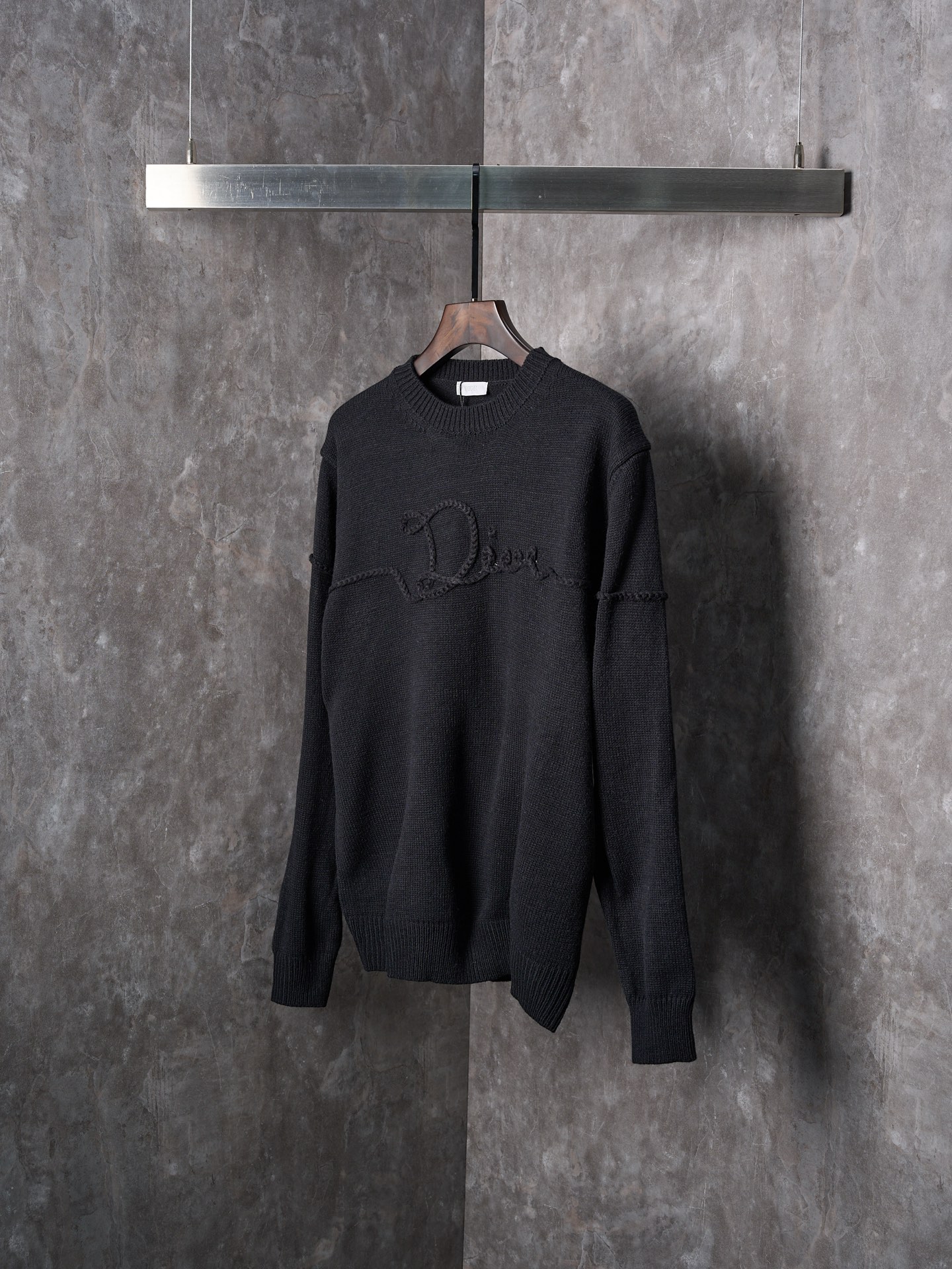 P225


【实物挂拍】DIOR/迪奥 机缝线绣标识针织圆领长袖毛衣


【颜色】黑色 杏色
【现货】S M L XL

这款针织衫是二零二六春季男装系列新品，饰以Dior Ribbon 标志，向Dior 工坊的精湛工艺致敬。采用白色绵羊毛平纹针织面料精心制作，搭配罗纹圆领、袖口和底边。优雅版型，可与牛仔裤搭配，打造休闲时髦的精致造型。
Dior Ribbon 刺绣，罗纹圆领、袖口和底边

采用50%羊毛，50%棉纱。
胸口徽标采用正7针进口机织出，大小尺寸按原版1：1数据定织。
成衣洗水-去除羊毛表面杂质-固色-固定版型-添加手感。