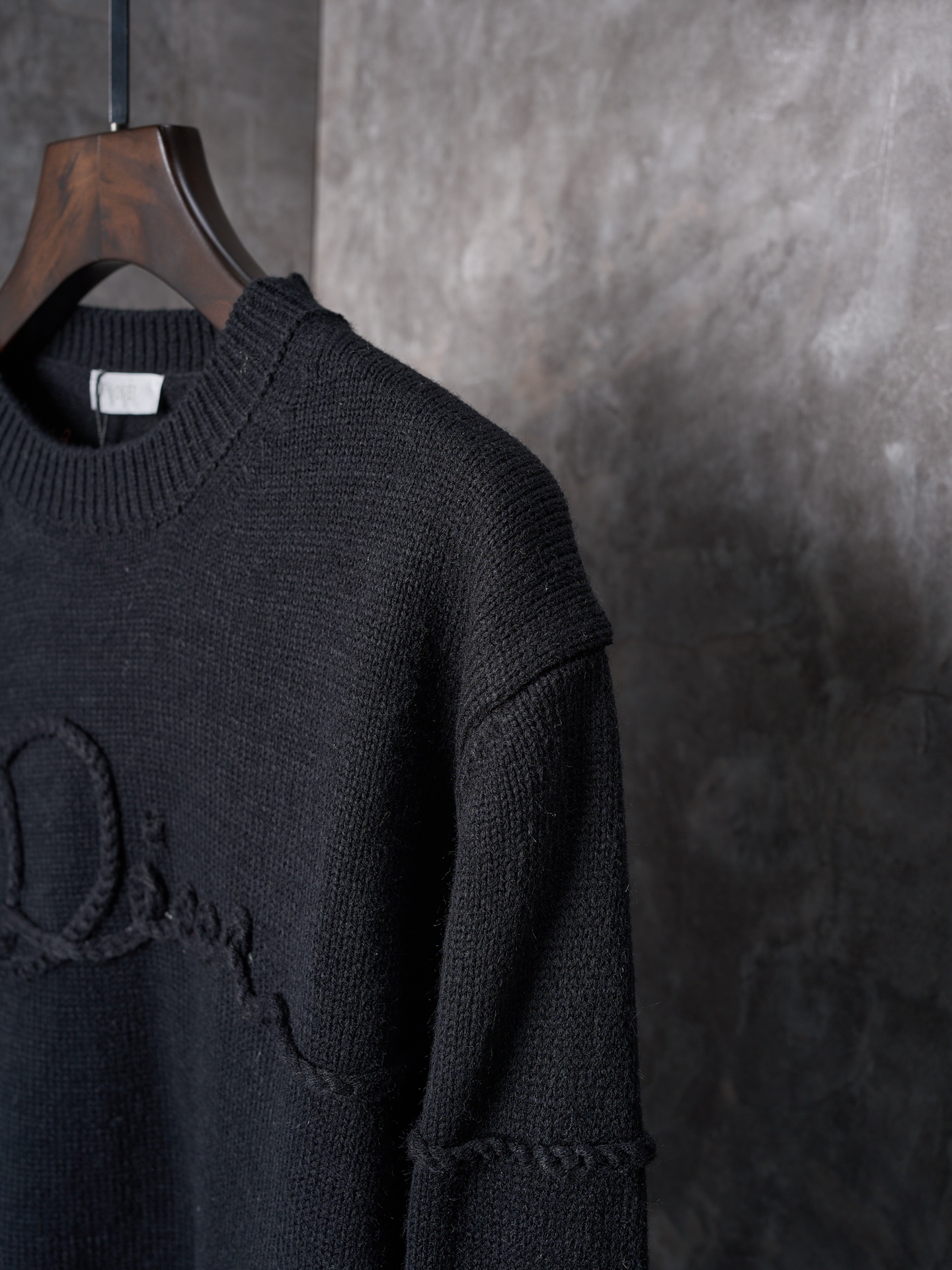 P225


【实物挂拍】DIOR/迪奥 机缝线绣标识针织圆领长袖毛衣


【颜色】黑色 杏色
【现货】S M L XL

这款针织衫是二零二六春季男装系列新品，饰以Dior Ribbon 标志，向Dior 工坊的精湛工艺致敬。采用白色绵羊毛平纹针织面料精心制作，搭配罗纹圆领、袖口和底边。优雅版型，可与牛仔裤搭配，打造休闲时髦的精致造型。
Dior Ribbon 刺绣，罗纹圆领、袖口和底边

采用50%羊毛，50%棉纱。
胸口徽标采用正7针进口机织出，大小尺寸按原版1：1数据定织。
成衣洗水-去除羊毛表面杂质-固色-固定版型-添加手感。