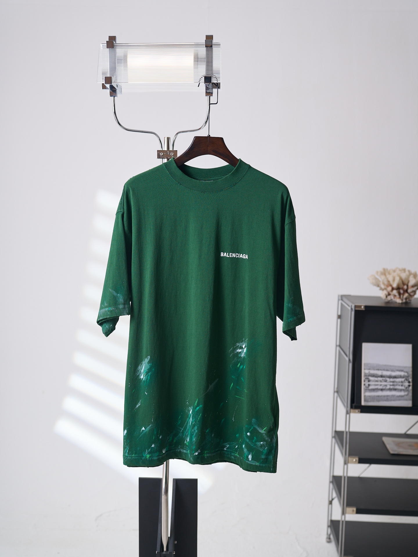 NO:936724,[Real auction] Balenciaga/Balenciaga letter embroidered graffiti loose round neck short-sleeved T-shirt [ready stock] XS S M L fabric 24 count special woven compact cotton / 185G rib 32 count 1×1 rib / 270G  Compact spinning technology eliminates hairiness on the yarn surface through an airflow gathering device, making the yarn smooth and round. The fabric presents a fine, micro-matte texture, and is smooth and skin-friendly. The 185g light and thin structure of the fabric ensures dryness and breathability for summer wear. The high-density ribbing on the neckline is paired with spandex elastic fiber to provide long-lasting resilience, so that the neckline remains close to the neck after being put on and taken off multiple times, washed and aged, and is not easy to loosen and deform, taking into account both comfort and durability.  The stitches of the needle embroidery penetrate the fabric just right, which not only ensures the firmness of the pattern, but also does not wrinkle the fabric due to too high needle density. This technique can create a three-dimensional effect of light and shadow flow through changes in angle and density, making the logo clearly highlighted on the green base fabric, which combines exquisite craftsmanship and artistic expression.  The random effect of paint splashing and splattering in street graffiti is simulated by manual screen scraping combined with local manual dripping. Manual scraping creates brush marks and fly whites of varying widths, and then manual dripping and low-pressure spray guns create fine paint splash points. The thickness and coverage of the printing paste are deliberately changed to give the pattern a natural handmade feel.  The ready-made garments are first washed with enzymes to make the fabric feel soft and have a uniform fading effect; then, manual distressing and hole processing is performed in designated areas, and special tools are used to create controlled wear and holes in the fabric to simulate natural damage after long-term wear; and finally, water washing is performed to remove floating colors and residual chemicals, and softeners are added to make the fabric feel fluffy.,,balenciaga,balenciaga,T-shirt,tees,t-shirt,19860909【实物挂拍】Balenciaga/巴黎世家 字母刺绣涂鸦宽松圆领短袖T恤【现货】XS S M L 面料24支特纺紧密棉 / 185G 罗纹32支1×1罗纹 / 270G 紧密纺技术通过气流集聚装置消除纱线表面毛羽,使纱体光洁圆润,面料呈现细腻微雾面质感,触感柔滑亲肤.面料185g轻薄结构确保夏日穿着干爽透气.领口高密度罗纹搭配氨纶弹力纤维,提供持久回弹力,使领口在多次穿脱及洗水做旧处理后依然紧贴颈部,不易松弛变形,兼顾舒适度与耐用性. 挨针刺绣的针迹恰到好处地穿透面料,既保证了图案的牢固度,又不会因针密过高而拉皱面料.该技法可通过角度与疏密变化塑造光影流动的立体效果,使标识在绿色底布上清晰凸显,兼具精致工艺与艺术表现力. 模拟街头涂鸦中油漆泼洒、飞溅的随机效果,通过手工丝网刮印结合局部手工滴洒实现.手工刮印制造宽窄不一的刷痕与飞白,再以手工滴洒和低压喷枪制造细密颜料飞溅点.印花浆料的厚薄与覆盖程度刻意制造变化,使图案呈现自然手工感. 先对成衣进行酵素洗,使面料手感柔软并产生均匀褪色效果；随后在指定区域进行人手做旧破洞处理,专用工具在面料上制造可控磨损与破洞,模拟长期穿着后的自然破损；最后水洗去除浮色与残留化学剂,并添加柔软剂使面料手感蓬松.,,balenciaga,balenciaga,T-shirt,tees，t-shirt,,Men's clothing