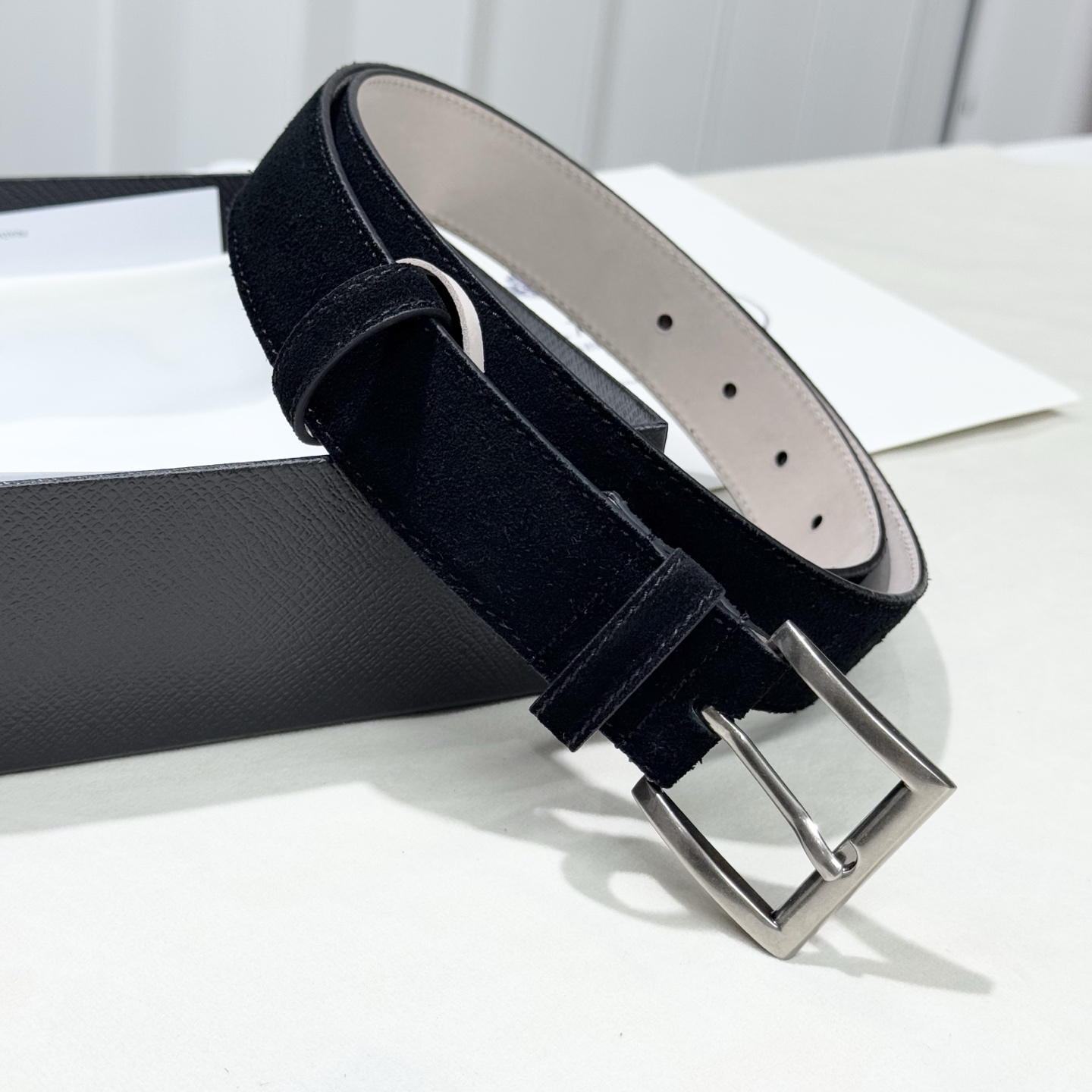 。 男女通用，P rada这款华美的绒面皮革腰带释放简约而精致的优雅气息 尖部的涂珐琅金属三角形徽标展现