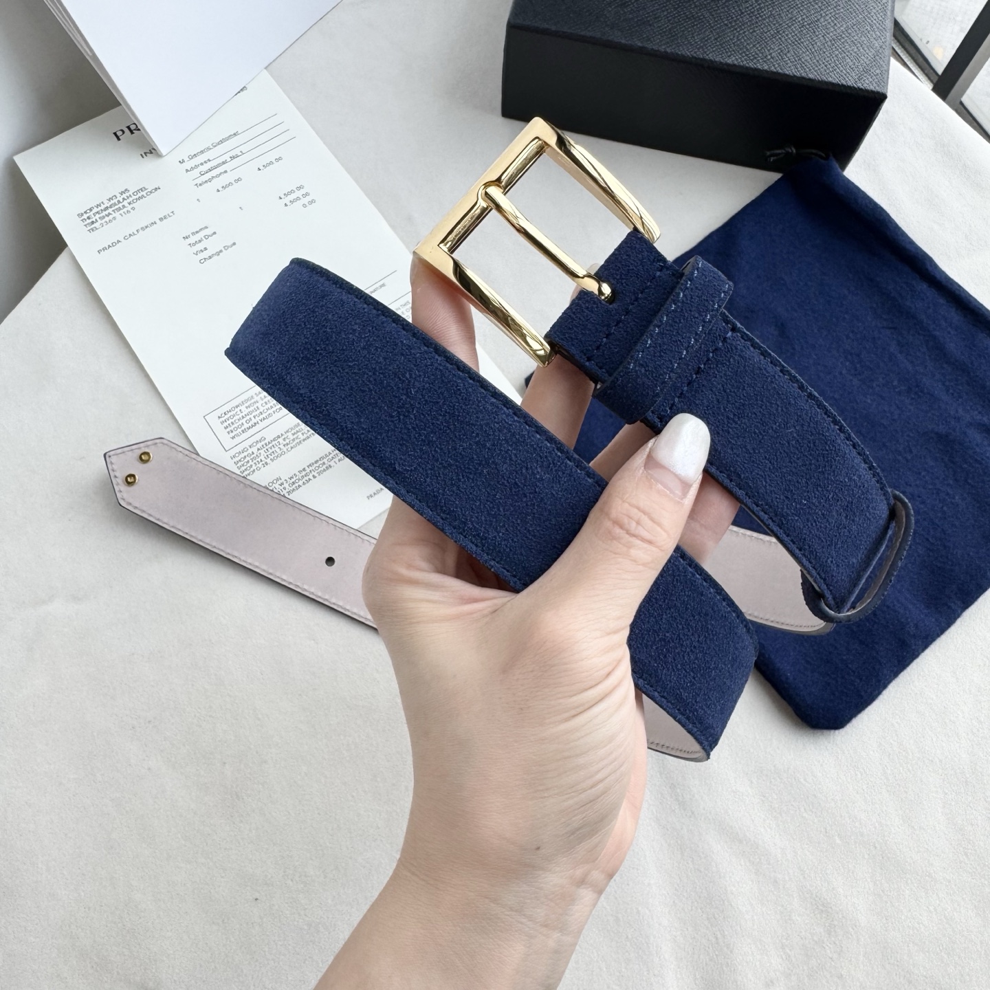 。 男女通用，P rada这款华美的绒面皮革腰带释放简约而精致的优雅气息 尖部的涂珐琅金属三角形徽标展现