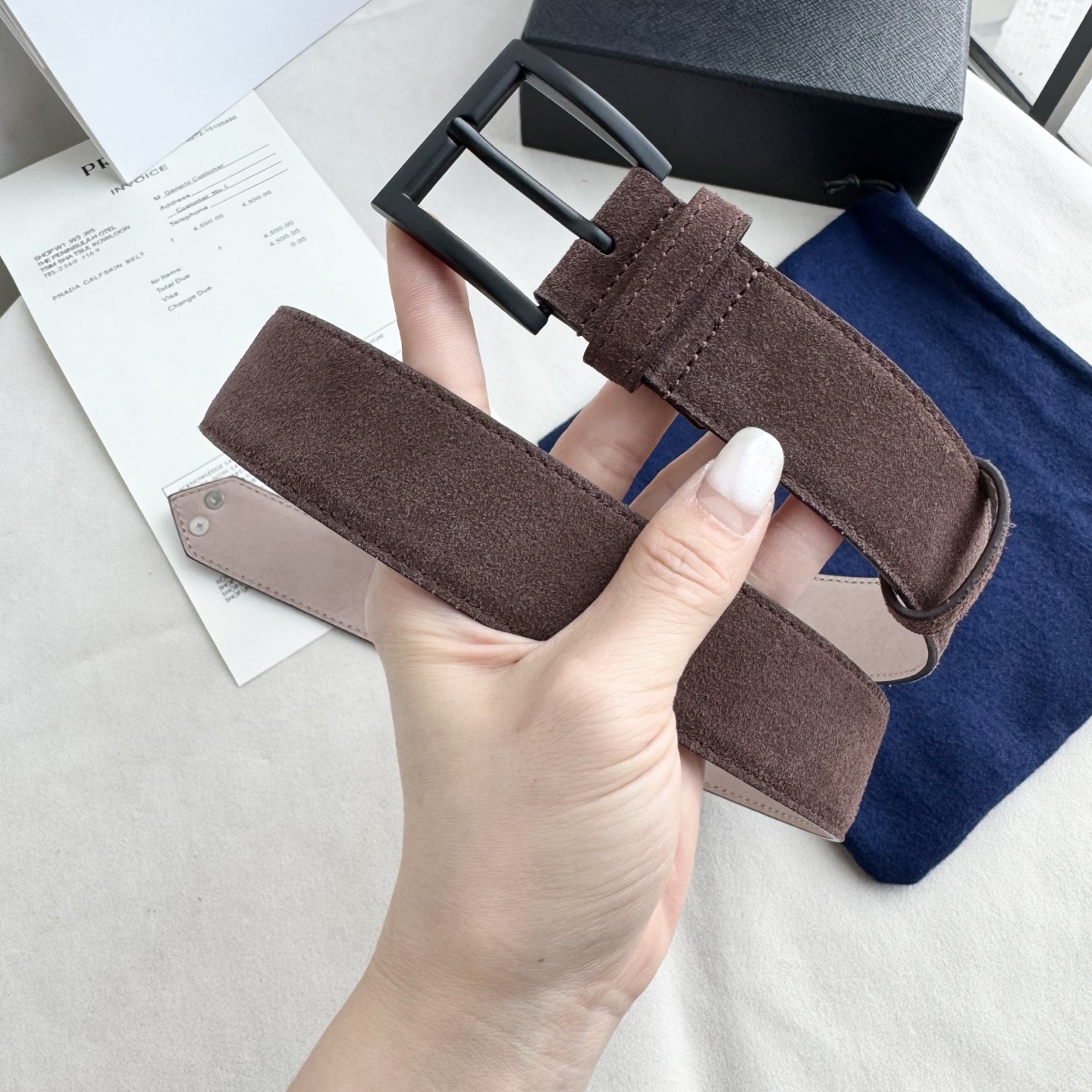 。 男女通用，P rada这款华美的绒面皮革腰带释放简约而精致的优雅气息 尖部的涂珐琅金属三角形徽标展现