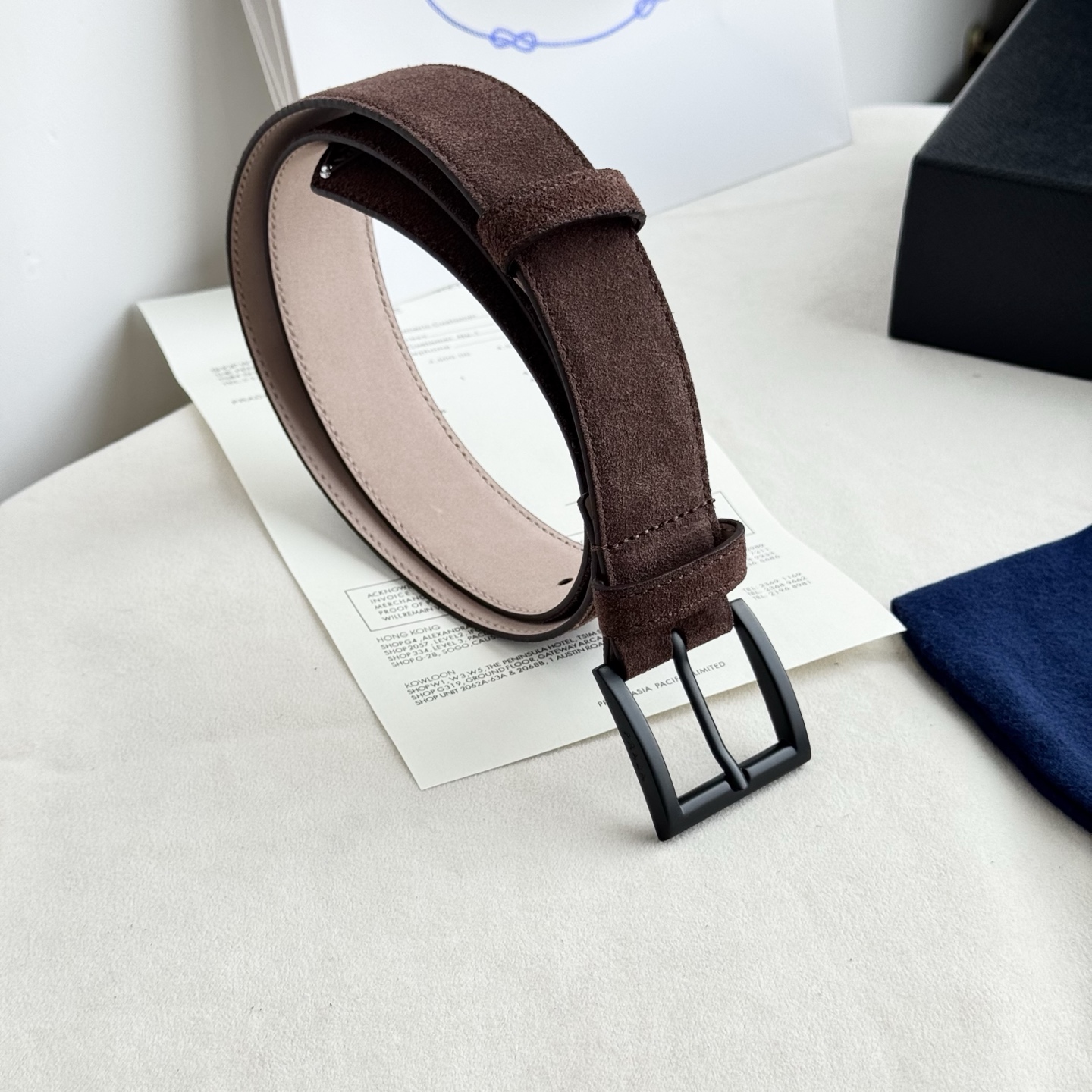 。 男女通用，P rada这款华美的绒面皮革腰带释放简约而精致的优雅气息 尖部的涂珐琅金属三角形徽标展现