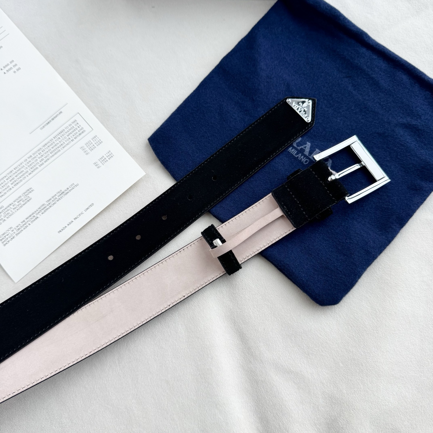 。 男女通用，P rada这款华美的绒面皮革腰带释放简约而精致的优雅气息 尖部的涂珐琅金属三角形徽标展现