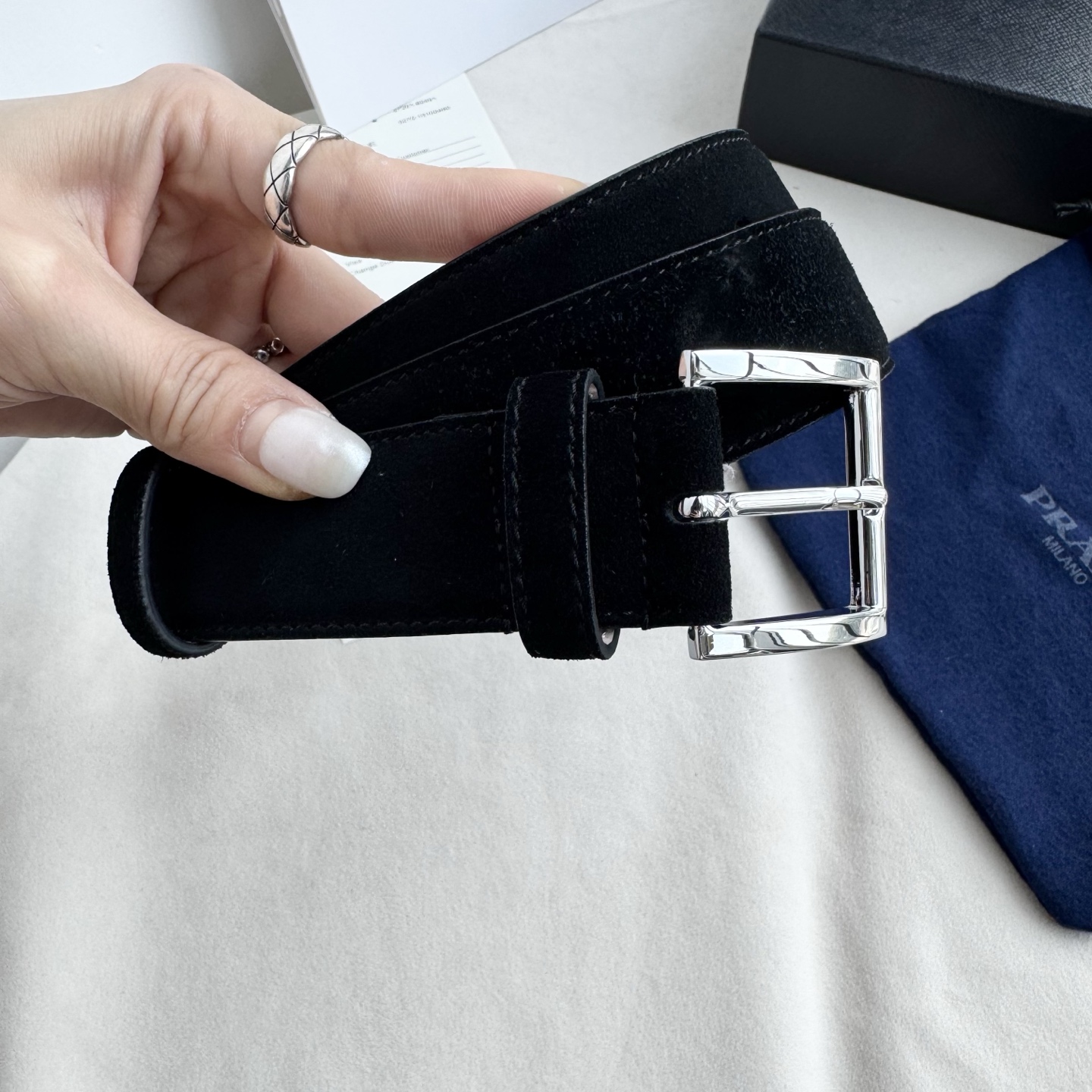 。 男女通用，P rada这款华美的绒面皮革腰带释放简约而精致的优雅气息 尖部的涂珐琅金属三角形徽标展现