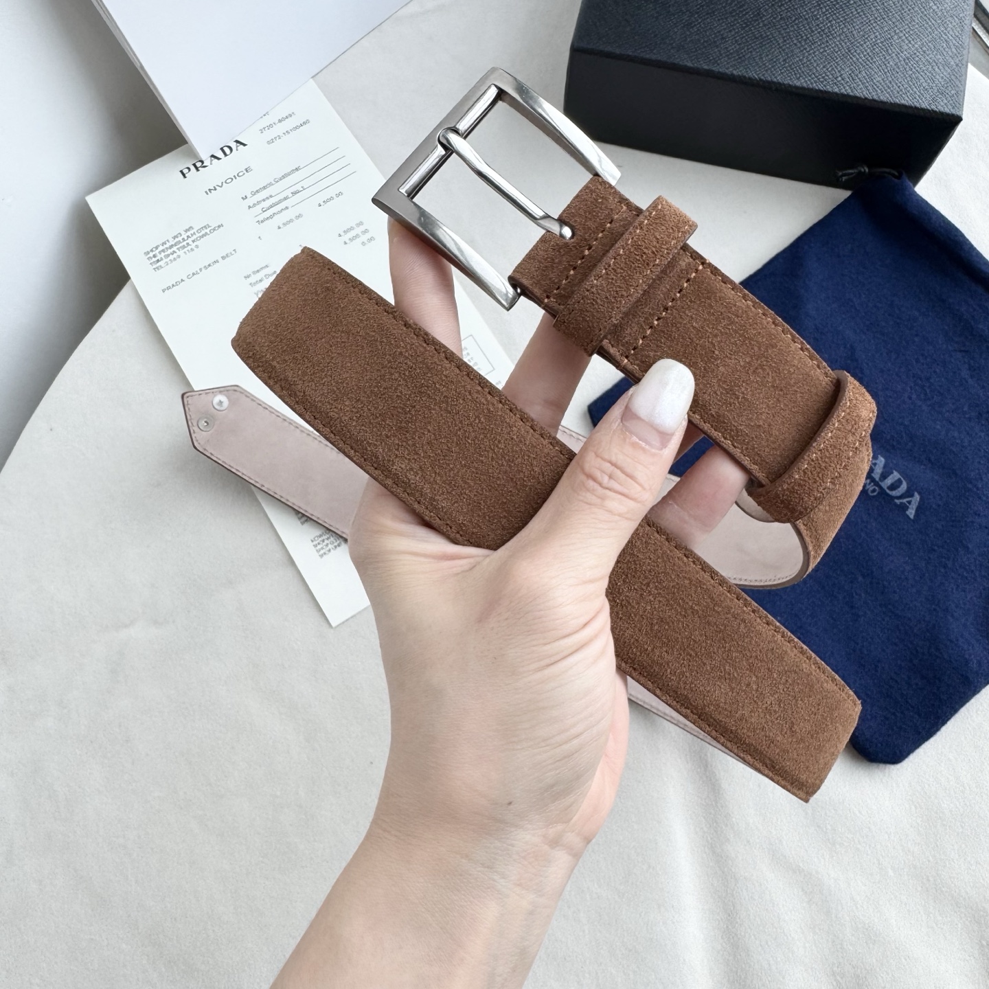。 男女通用，P rada这款华美的绒面皮革腰带释放简约而精致的优雅气息 尖部的涂珐琅金属三角形徽标展现