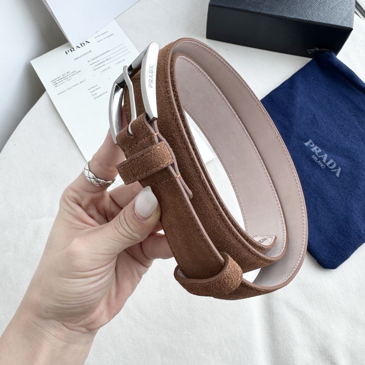 。 男女通用，P rada这款华美的绒面皮革腰带释放简约而精致的优雅气息 尖部的涂珐琅金属三角形徽标展现