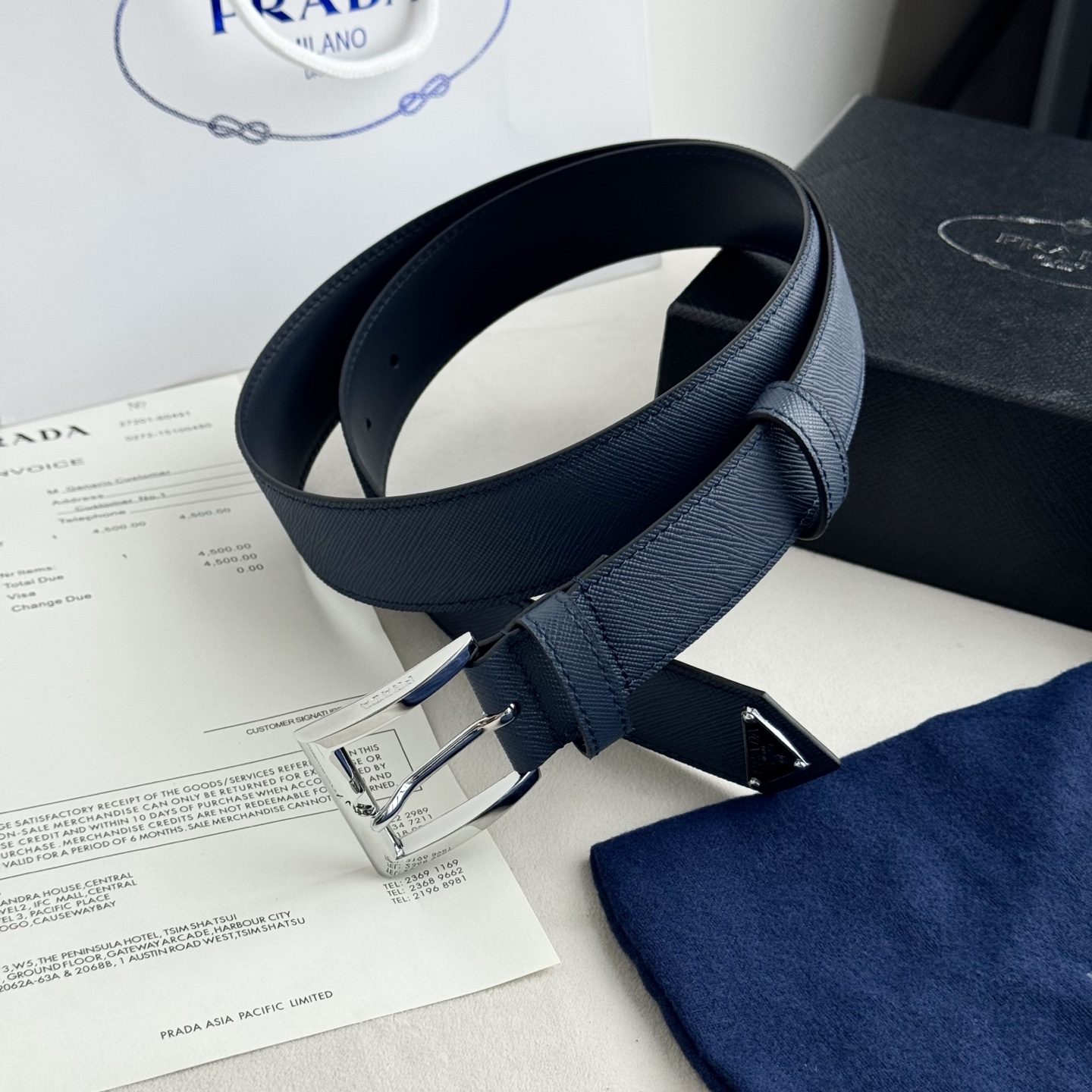 。 男女通用，P rada这款华美的十字纹牛皮腰带释放简约而精致的优雅气息 尖部的涂珐琅金属三角形徽标展