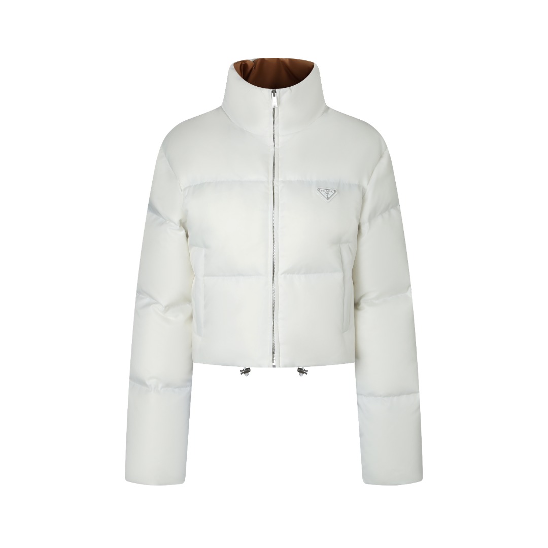 NO:536068,PRADA high-waist stand-collar down jacket with dust bag front fabric selection. The brand's signature recycled nylon fabric is comparable to traditional nylon, with high strength, tear resistance, wear resistance and other characteristics. Its texture is light and waterproof, and is suitable for multiple scenarios. Its wrinkle and quick drying characteristics are also easy to maintain and maintain daily. The lining is made of polyamide. Polyamide fiber is known for its extremely high strength and excellent skin-friendly feeling. It feels silky smooth, avoiding the friction discomfort that may occur when wearing heavy underwear. It works in concert with the outer nylon to jointly build a breathable, temperature-locking, and extremely comfortable microclimate environment, allowing warm care to be always online, without any stuffiness and restraint. High-quality filler Select 90 white duck down, weighing 280g, to ensure excellent warmth performance. After strict screening and processing of the velvet, it is not easy to drill velvet, ensuring durability. The core of warmth is to use advanced grid filling technology to evenly fill the precious 90 high-quality white duck down into each independent vertical lining grid. This process effectively prevents the accumulation or sinking of the velvet during the wear process, ensures that the front, back, left and right are all-round warmth without dead corners, and at the same time, the silhouette of the velvet is always full and crisp, avoiding bloating. All stitches are adopted in the industry-respective double-needle quilting process, with fine and even stitches, such as strict defense lines, which are not only firm and beautiful, but also eliminates the worries of the velvet from the stitches to a great extent, ensuring the product's lasting warmth performance. The auxiliary materials are compared with the custom-made breast marks, the custom-made hardware, the custom-made auxiliary materials, the custom-made auxiliary materials, the custom-made auxiliary materials, the custom-made auxiliary materials, the custom-made, prada, down Jacket,alexander wang19860909PRADA高腰立领羽绒服 配防尘袋正面面料选择 选用品牌标志性的再生尼龙面料,与传统尼龙性能相当,具备高强度,抗撕裂,耐磨损等特性.其质地轻盈,同时又具备防水功能适合多场景需求.抗皱,快干的特点也易于日常打理维护. 内衬采用了聚酰胺材质. 聚酰胺纤维以其极高的强度与卓越的亲肤感著称,触感如丝般顺滑,避免了穿着厚重内衣时可能产生的摩擦不适.它与外层尼龙协同工作,共同构建了一个透气、锁温、且极度舒适的微气候环境,让温暖呵护时刻在线,却毫无闷热与束缚感 高品质填充物 选用90白鸭绒,克重达280g,确保保暖性能卓越.绒子经过严格筛选与处理之后,不易钻绒,保证了耐用性 保暖核心在于采用先进的分格充绒技术,将珍贵的90优质白鸭绒均匀填充至每一个独立立衬方格内.这种工艺有效防止了绒朵在穿着过程中的堆积或下沉,确保了前后左右全方位的保暖无死角,同时令衣身廓形始终饱满挺括,避免臃肿. 所有缝线处均采用业内推崇的精密双针绗缝工艺,针脚细密均匀,如一道道严谨的防线,不仅牢固美观,更极大程度地杜绝了绒朵从缝线钻出的烦恼,保证了产品持久的保暖性能 辅料一比一定制胸标  一比一定制五金  一比一定制辅料,,prada,down jacket,alexander wang,Women's clothing