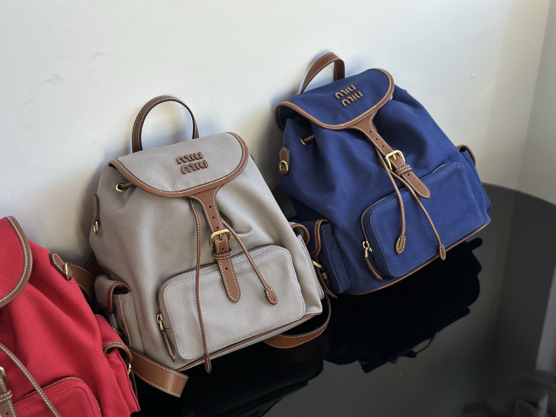 Miu Miu Lets take a look at the actual photos of miumiu backpack. Three colors: red, royal blue, light gray. Made in Dongguan. Absolutely matchin