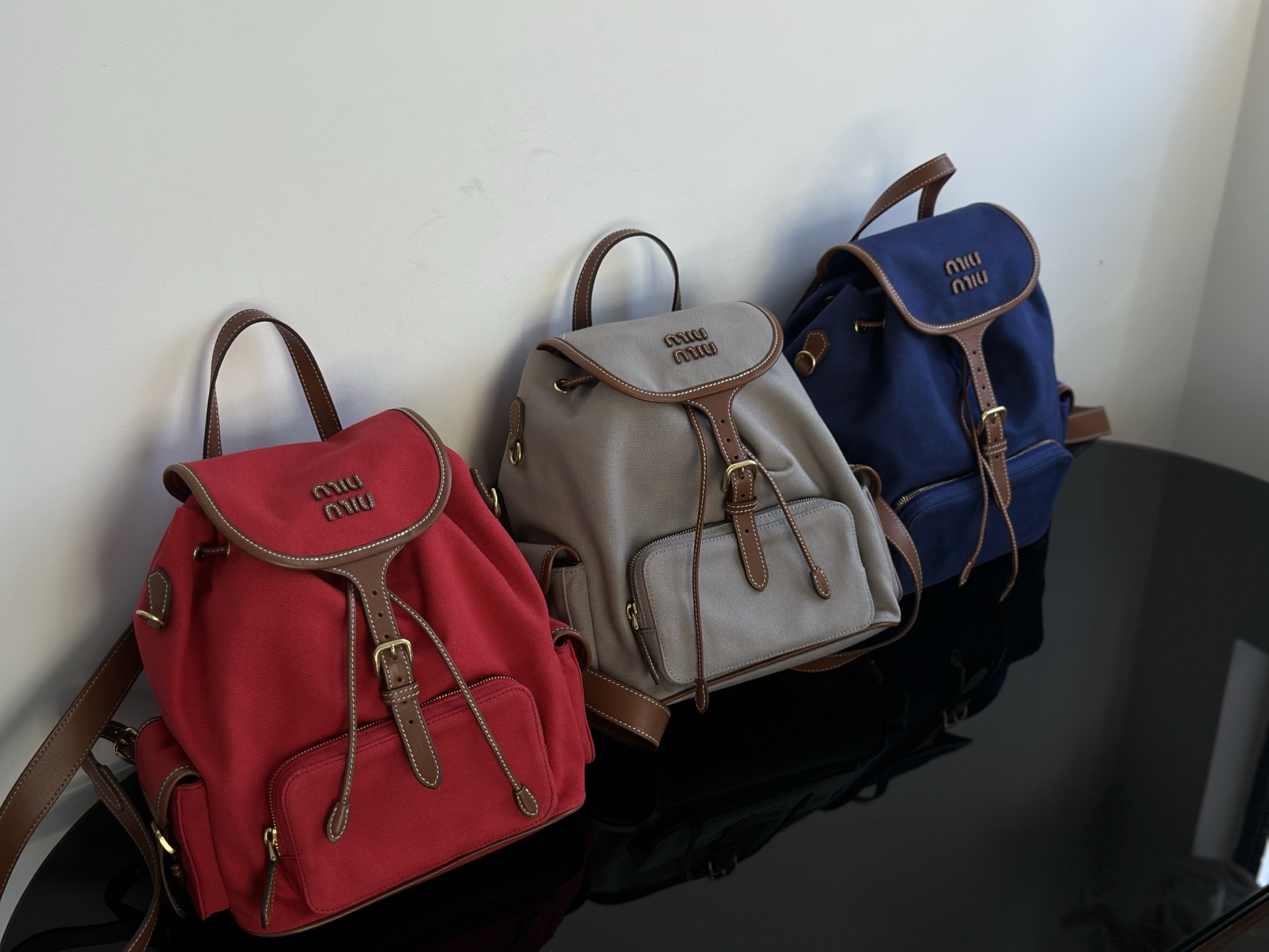Miu Miu Lets take a look at the actual photos of miumiu backpack. Three colors: red, royal blue, light gray. Made in Dongguan. Absolutely matchin