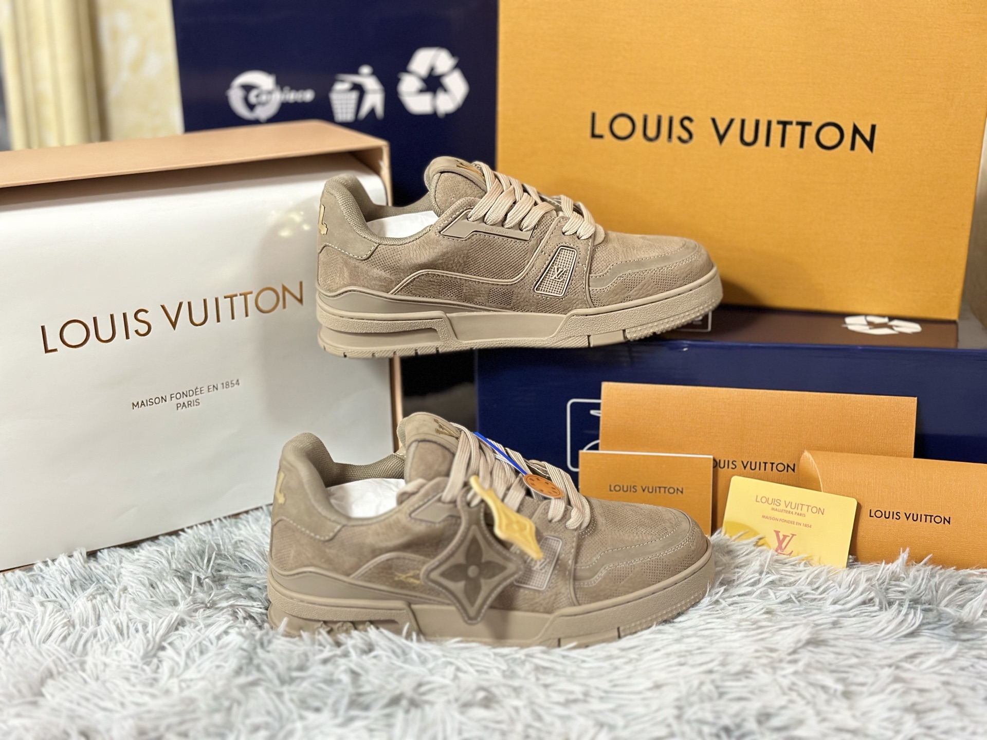 NO:730129,High version in stock LOUIS VUITTON Trainer, a miniature leather work of art that goes beyond sports shoes. Sizes 35-39 for women and 39-46 for men. Its construction philosophy is rooted in high-end leather goods workshops. The body of the shoe is like a deconstructed suitcase. It is made of box calf leather, suede and Damier coated canvas for leather inlay technology. The edges are processed by hand and beeswax stitched. The inner lining is made of Veau.  Velours cashmere leather, and the insole is filled with memory foam and wool blend lining like a custom suit shoulder pad, providing a kind of secret comfort 'supported by luxury'. The outsole is not just rubber, but multi-layered vulcanized rubber that imitates the corners of antique luggage. The surface is sandblasted and hand-brushed to present a warm and moist texture that has been used for many years. The Monogram relief on the side wall is not printed, but is hot-pressed with a micron-level mold, and each hollow is precisely corresponding to the leather seam.  Ultimately, it combines trunk-making tradition (travel), haute couture (tailoring) and sporty silhouettes (body), becoming an identity metaphor for the 'contemporary wanderer' - wherever your feet touch, there is a show.,, louis vuitton, sneakers, business suit, cowhide, chamois leather19860909高版本 现货 LOUIS VUITTON Trainer,超越运动鞋范畴的微型皮具艺术品. 尺码女 35-39 男 39-46 其构造哲学植根于高级皮具工坊鞋身如一件解构的旅行箱,采用box calf小牛皮、反绒麂皮与Damier涂层帆布进行皮革镶嵌工艺拼贴,边缘经手工床面处理与蜜蜡缝线收边.内衬使用Veau Velours羊绒皮革,鞋垫则如定制西装垫肩般填入记忆海绵与羊毛混纺衬里,提供一种“被奢华承托”的隐秘舒适. 外底并非单纯橡胶,而是模仿古董行李箱包角的多层硫化橡胶,表面进行喷砂与手刷处理,呈现经年使用的温润质感.侧壁的Monogram浮雕并非印花,而是通过微米级模具热压成型,每一处镂空皆精准对应皮革接缝. 最终,它将制箱传统（旅行）、高级成衣（剪裁）与运动轮廓（身体）融于一体,成为一种关于“当代漫游者”的身份隐喻——双脚所及之处,皆是秀场.,,louis vuitton,sneakers,business suit,cowhide,chamois leather,Men's shoes