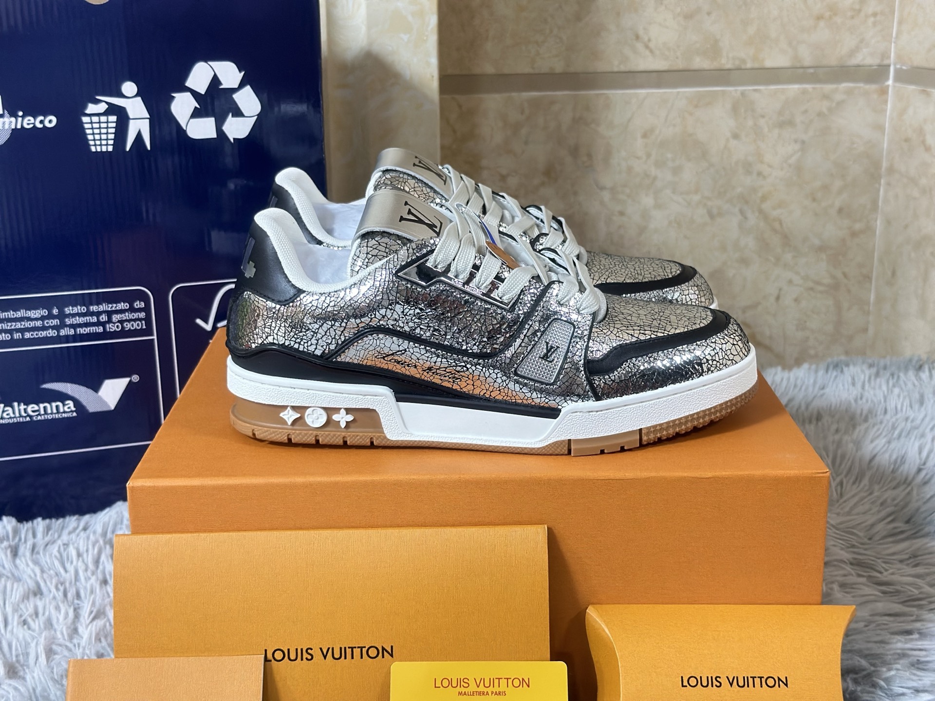 NO:730155,High version in stock LOUIS VUITTON Trainer, a miniature leather work of art that goes beyond sports shoes. Sizes 35-39 for women and 39-46 for men. Its construction philosophy is rooted in high-end leather goods workshops. The body of the shoe is like a deconstructed suitcase. It is made of box calf leather, suede and Damier coated canvas for leather inlay technology. The edges are processed by hand and beeswax stitched. The inner lining is made of Veau.  Velours cashmere leather, and the insole is filled with memory foam and wool blend lining like a custom suit shoulder pad, providing a kind of secret comfort 'supported by luxury'. The outsole is not just rubber, but multi-layered vulcanized rubber that imitates the corners of antique luggage. The surface is sandblasted and hand-brushed to present a warm and moist texture that has been used for many years. The Monogram relief on the side wall is not printed, but is hot-pressed with a micron-level mold, and each hollow is precisely corresponding to the leather seam.  Ultimately, it combines trunk-making tradition (travel), haute couture (tailoring) and sporty silhouettes (body), becoming an identity metaphor for the 'contemporary wanderer' - wherever your feet touch, there is a show.,, louis vuitton, sneakers, business suit, cowhide, chamois leather19860909高版本 现货 LOUIS VUITTON Trainer,超越运动鞋范畴的微型皮具艺术品. 尺码女 35-39 男 39-46 其构造哲学植根于高级皮具工坊鞋身如一件解构的旅行箱,采用box calf小牛皮、反绒麂皮与Damier涂层帆布进行皮革镶嵌工艺拼贴,边缘经手工床面处理与蜜蜡缝线收边.内衬使用Veau Velours羊绒皮革,鞋垫则如定制西装垫肩般填入记忆海绵与羊毛混纺衬里,提供一种“被奢华承托”的隐秘舒适. 外底并非单纯橡胶,而是模仿古董行李箱包角的多层硫化橡胶,表面进行喷砂与手刷处理,呈现经年使用的温润质感.侧壁的Monogram浮雕并非印花,而是通过微米级模具热压成型,每一处镂空皆精准对应皮革接缝. 最终,它将制箱传统（旅行）、高级成衣（剪裁）与运动轮廓（身体）融于一体,成为一种关于“当代漫游者”的身份隐喻——双脚所及之处,皆是秀场.,,louis vuitton,sneakers,business suit,cowhide,chamois leather,Men's shoes