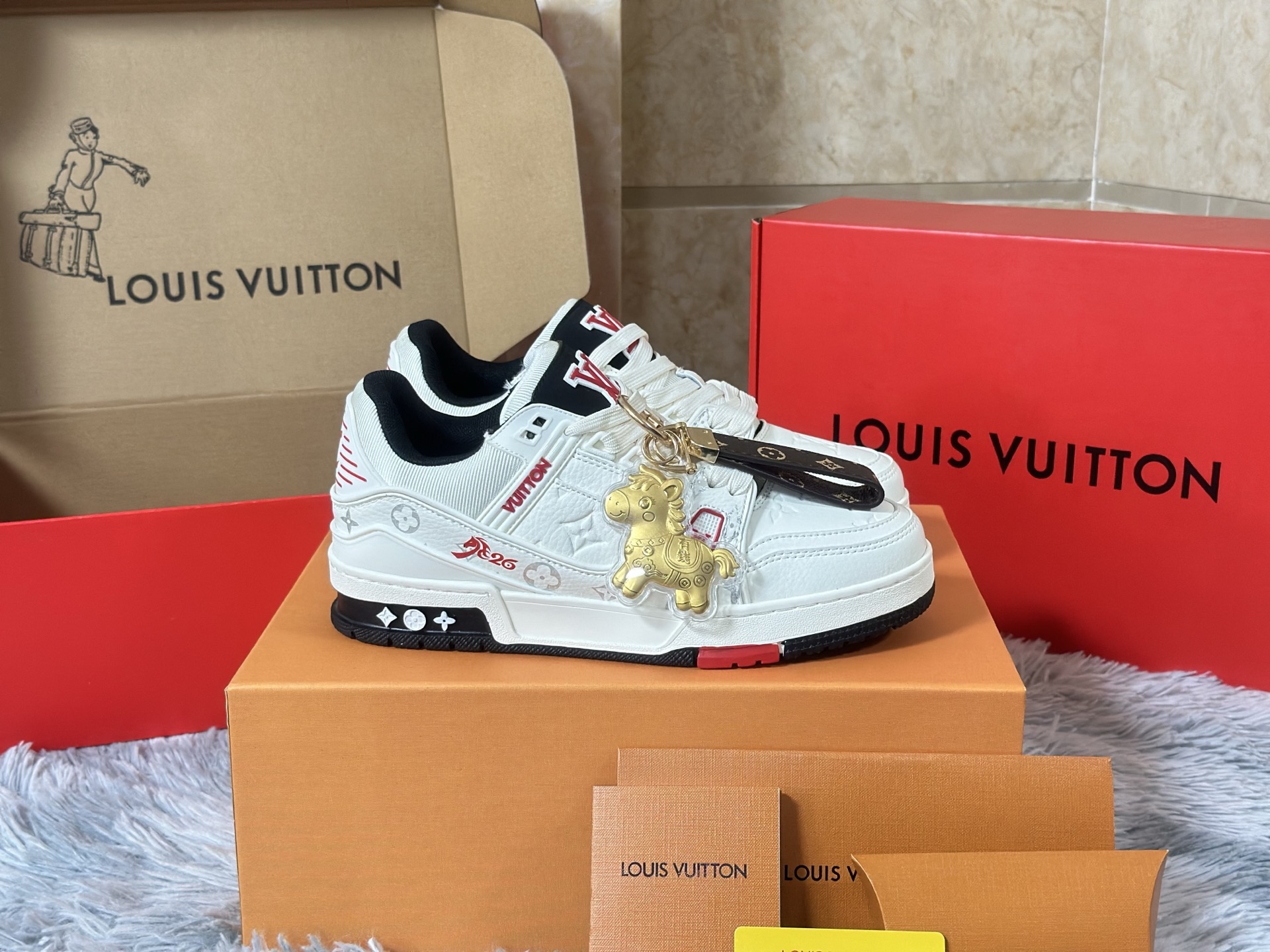 NO:730165,In stock Airplane box version Size 36-45 Couple model LOUIS VUITTON 'Year of the Horse Limited' Trainer is a miniature epic dedicated to the zodiac totem by a high-end leather goods workshop. The body of the shoe is like a mobile collection cabinet, and the main body is made of Box  Calf smooth calfskin carves out the outline of a three-dimensional saddle, and the sides are spliced with Ostrich ostrich leather that has been specially tanned to present a saddle brown gradient color, imitating the flowing texture of horse fur. The iconic Monogram flower is not printed, but covered with laser hollow leather lamination technology on the dark red suede, as if the brand soul is imprinted on the harness.  The inner lining is made of silk printed with the replica pattern of the first LV harness order in 1896, and the inside of the tongue is hand-painted with a miniature gold foil horse head badge. The midsole is not ordinary rubber, but a composite material injected with metal powder, which is polished to give a warm luster like bronze. The outsole pattern is made of traditional horseshoe forging patterns intertwined with LV diamond patterns.  It transcends the general categories of sports shoes or luxury goods and has become a triple totem that connects the centuries-old saddlery family tradition, zodiac culture and contemporary street aesthetics - every time you wear it, you are completing a journey across time.,, louis vuitton, louis vuitton, sneakers, cowhide, ostrich skin, chamois leather19860909现货 飞机盒版本 尺码36-45 情侣款 LOUIS VUITTON “马年限定” Trainer,是高级皮具工坊献给生肖图腾的一首微缩史诗. 鞋身如一座移动的典藏柜,主体采用Box Calf光面小牛皮雕琢出立体鞍具轮廓,侧面拼接经特殊鞣制呈现马鞍棕渐变色的Ostrich鸵鸟皮,模仿骏马皮毛的流光质感.标志性的Monogram花卉并非印花,而是以激光镂空皮革层压技术覆盖于深红色麂皮之上,如同将品牌灵魂烙刻于马具. 内衬选用印有1896年首份LV马具订单复刻图案的丝绸,鞋舌内侧则手绘微型金箔马首徽章.中底并非普通橡胶,而是注入金属粉末的复合材质,经抛光呈现青铜器般的温润光泽,外底纹路由传统马蹄铁锻造纹路与LV菱形格交织而成. 它超越了运动鞋或奢侈品的一般范畴,成为连接百年马具世家传统、生肖文化与当代街头美学的三重图腾——每一次穿着,皆是在完成一场跨越时间的巡礼.,,louis vuitton,louis vuitton,sneakers,cowhide,ostrich skin,chamois leather,Men's shoes