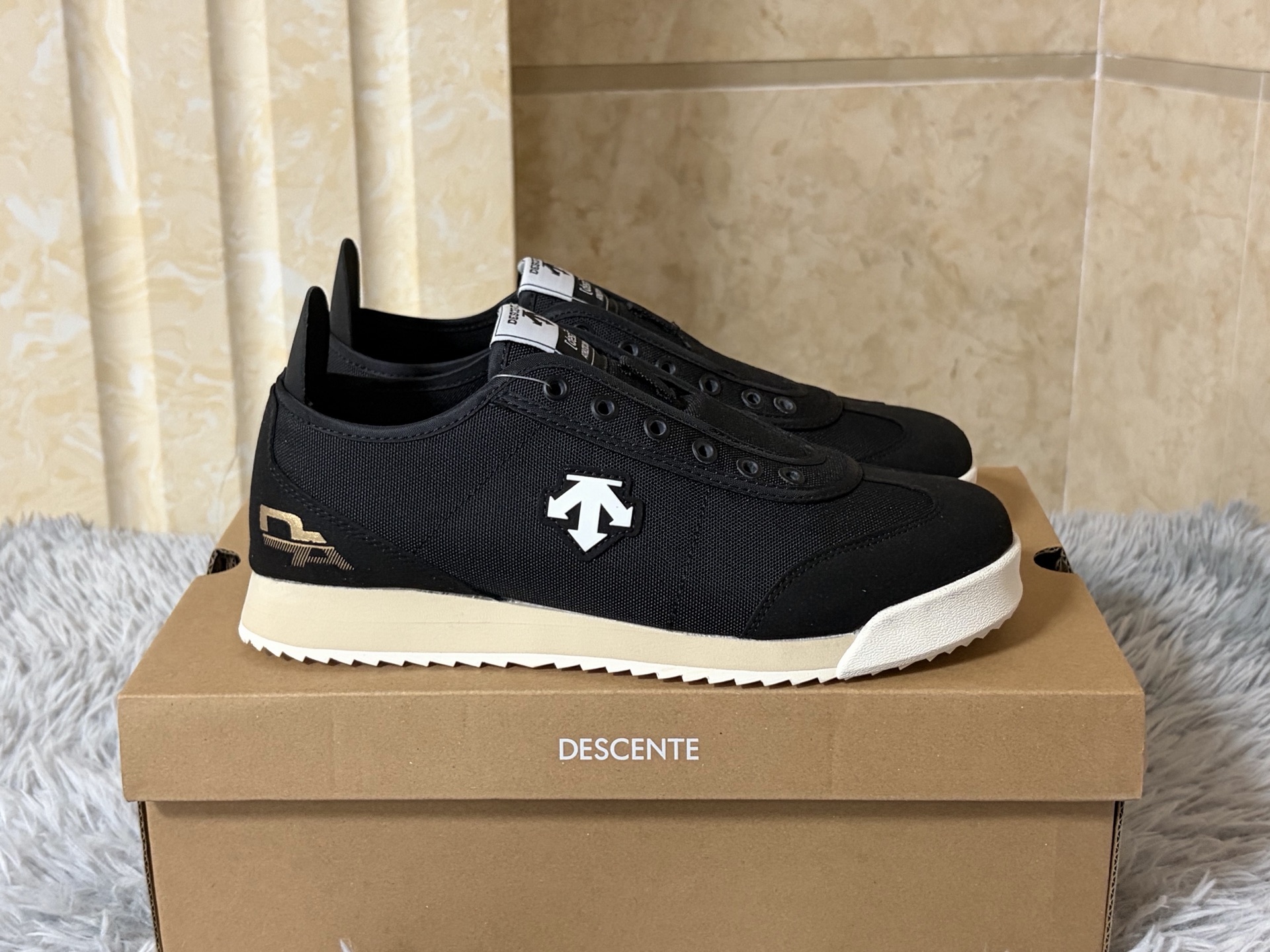 NO:888932,Slip-on ready stock, sizes 36-44 (with half sizes) Descente CHRON TEMPO SLIP-ON, in the shape of a slip-on, reshapes the relaxed rhythm of urban walking.  The shoe body is made of canvas and fabric splicing fabrics, which is light and breathable. The iconic arrow logo on the side injects retro genes in a low-key manner. The heel design allows for easy putting on and taking off and freedom of styling. Just step in and start off in seconds. Ortholi is built into the core.  The te cloud insole and lightweight IP midsole make the feet feel as soft and elastic as sinking into the clouds, and the soles of the feet will not be sore after walking for a long time. The low-cut silhouette is suitable for the casualness of jeans and the looseness of wide-leg pants, allowing comfort and style to flow naturally between steps.,,jeans19860909一脚蹬现货 尺码36-44（带半码） 迪桑特 CHRON TEMPO SLIP-ON,以一脚蹬之形,重塑都市漫步的松弛节奏. 鞋身精选帆布与织物拼接面料,轻盈透气,侧身标志性箭头Logo于低调中注入复古基因.可踩跟设计兼顾便捷穿脱与造型自由,一脚蹬入,秒速出发.核心内置Ortholite云朵鞋垫与轻量化IP中底,脚感软弹如陷云端,长时间行走足底不酸.低帮利落廓形,适配牛仔裤的随性与阔腿裤的松弛,让舒适与风格在步履间自然流转.,,jeans,Men's shoes