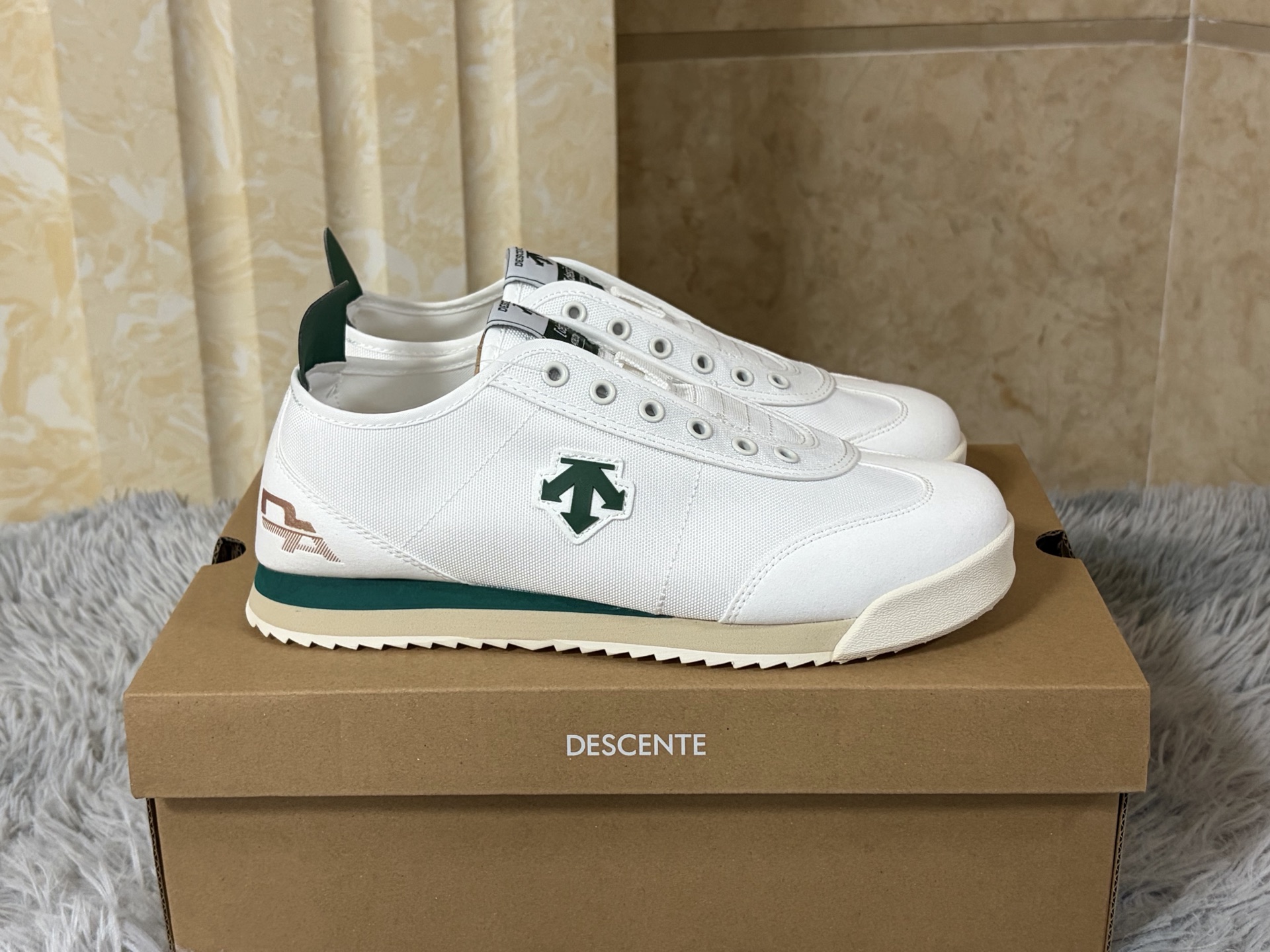 NO:888994,A slip-on for the next day. Sizes 36-44 (with half sizes included) Descente CHRON TEMPO SLIP-ON, in the shape of a slip-on, reshapes the relaxed rhythm of urban walking.  The shoe body is made of canvas and fabric splicing fabrics, which is light and breathable. The iconic arrow logo on the side injects retro genes in a low-key manner. The heel design allows for easy putting on and taking off and freedom of styling. Just step in and start off in seconds. Ortholi is built into the core.  The te cloud insole and lightweight IP midsole make the feet feel as soft and elastic as sinking into the clouds, and the soles of the feet will not be sore after walking for a long time. The low-cut silhouette is suitable for the casualness of jeans and the looseness of wide-leg pants, allowing comfort and style to flow naturally between steps.,,jeans19860909一脚蹬隔天 尺码36-44（带半码） 迪桑特 CHRON TEMPO SLIP-ON,以一脚蹬之形,重塑都市漫步的松弛节奏. 鞋身精选帆布与织物拼接面料,轻盈透气,侧身标志性箭头Logo于低调中注入复古基因.可踩跟设计兼顾便捷穿脱与造型自由,一脚蹬入,秒速出发.核心内置Ortholite云朵鞋垫与轻量化IP中底,脚感软弹如陷云端,长时间行走足底不酸.低帮利落廓形,适配牛仔裤的随性与阔腿裤的松弛,让舒适与风格在步履间自然流转.,,jeans,Men's shoes