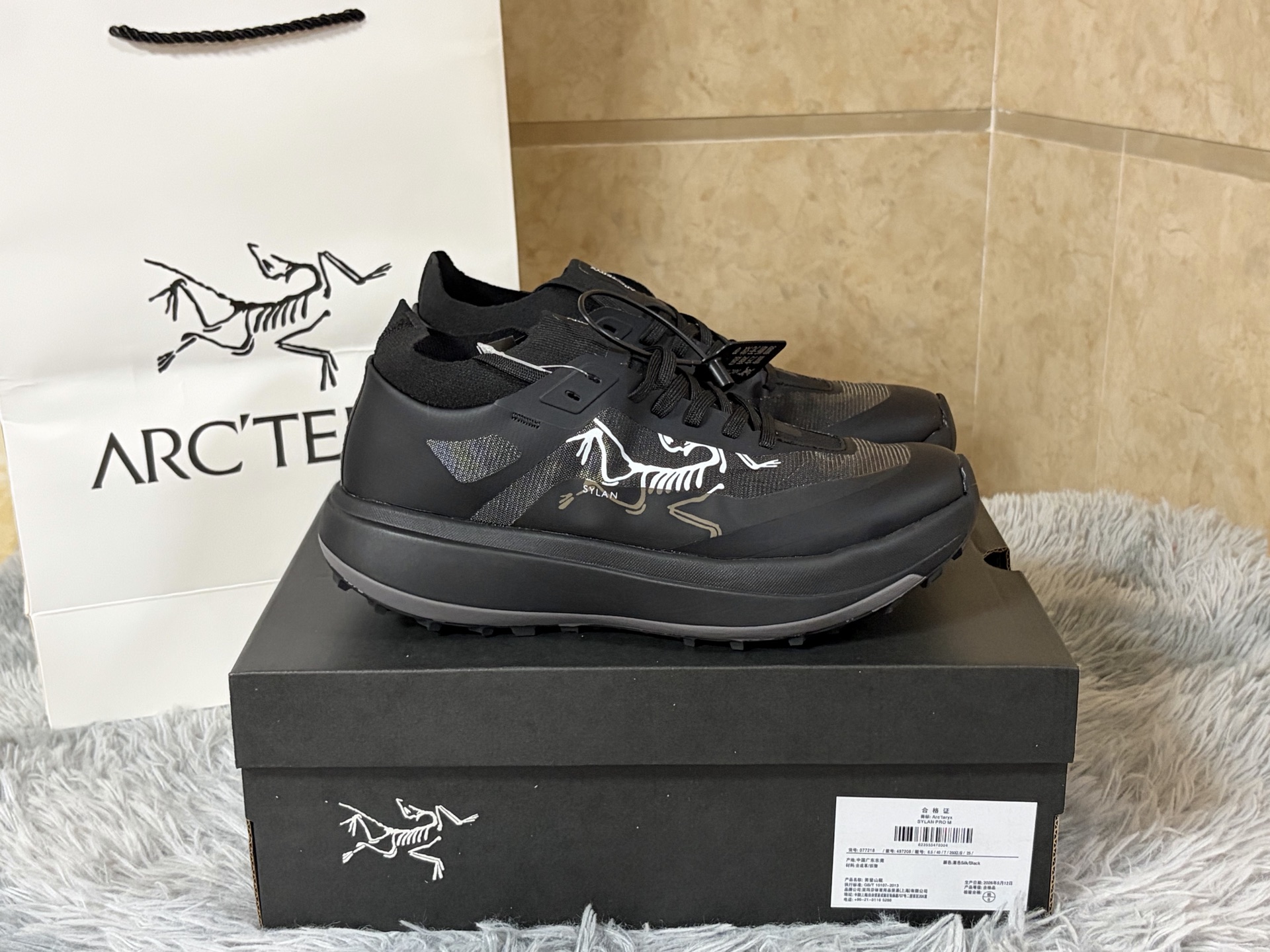 NO:888942,In stock, sizes 39-45 ARC'TERYX × BEAMS SYLAN PRO M, recasting the functional aesthetics of mountain racing from a Japanese trend perspective.  The whole body of the shoe is dipped in pure black, with a small amount of gray embedded in the midsole. The white Arc'teryx logo on the side and the brand logo on the shoe mouth outline the layers in a restrained manner, condensing the co-branding recognition between black and white. The upper is made of highly breathable technical mesh fabric, with an elastic knitted collar, which has both light fit and anti-sandstone intrusion functions. The core is equipped with InFuse dual-density midsole (EVA and polyolefin composite), combined with radical Rocker  The Geometry curved rolling structure provides continuous propulsion and impact absorption in rugged terrain. The outsole uses Vibram Megagrip wet non-slip rubber and LITEBASE lightweight technology, with customized multi-directional lug patterns that can lock the traction on slippery rock surfaces and loose soil slopes. From the precision structure of mountain racing to the Japanese trend aesthetic of black bottom, it is not only a pair of running shoes, but also a style statement across the mountains and streets., arc'teryx19860909现货 尺码 39-45 ARC'TERYX × BEAMS SYLAN PRO M,以日本潮流视角重铸山地竞速的机能美学. 鞋身通体浸染纯粹黑色,中底嵌合少量灰色,侧面白色始祖鸟满标与鞋口品牌标识于克制中勾勒层次,将联名辨识度凝练于黑白之间.鞋面采用高透气科技网眼织物,配合弹性针织鞋领,兼具轻盈贴合与防砂石侵入功能.核心搭载InFuse双密度中底（EVA与聚烯烃复合物）,配合激进Rocker Geometry弧形滚动结构,在崎岖地形中提供持续推进力与冲击吸收.外底采用Vibram Megagrip湿地防滑橡胶与LITEBASE轻量化技术,定制多向凸耳纹路在湿滑岩面与松散土坡皆可锁定抓地.从山地竞速的精密结构到一黑到底的日系潮流审美,不止是一双跑鞋,更是跨越山野与街头的风格宣言.,arc'teryx,Men's shoes