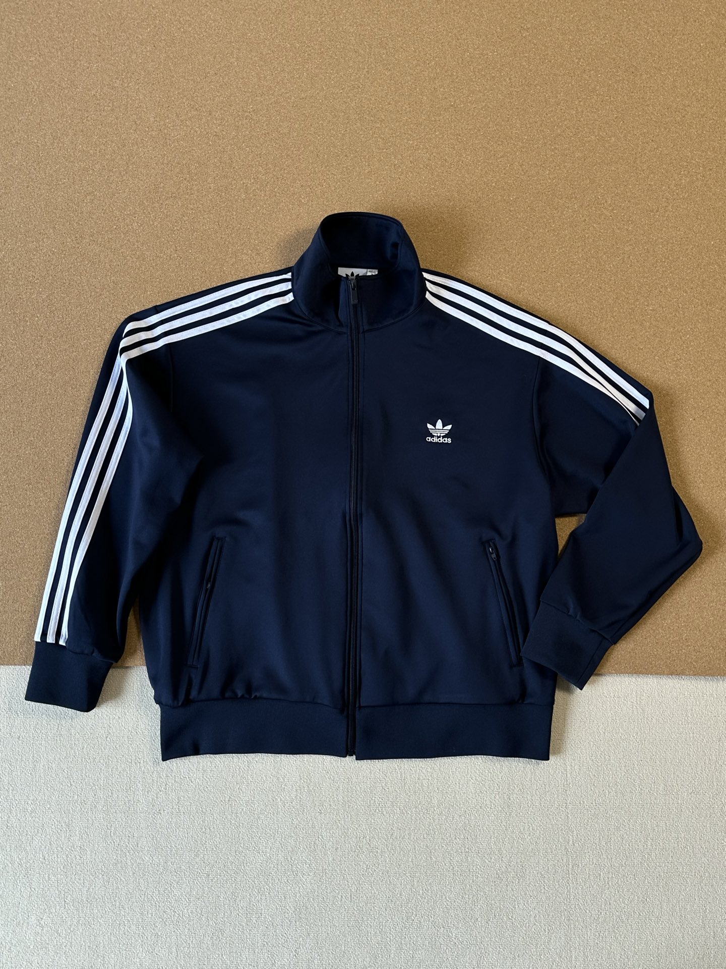 \n 同系列单品 超级明星同款 女神男神无脑入 韩版 Adidas Original adicolor 三条杠拼色 明星同款撞色三杠双开拉链刺绣外套 男女同款 \n\n\n颜色：深蓝色\n尺码：S M L XL XXL\n\n\n作为同系列的明星单品，它可是被众多超级明星青睐。无论你是优雅女神，还是帅气男神，都能无脑入手，轻松驾驭。经典的三条杠拼色设计，撞色大胆又吸睛，走在潮流前沿，瞬间提升整体造型的时尚感。\n\n双开拉链的细节设计，不仅实用，更增添了几分不羁的酷劲。精致的刺绣工艺，巧妙地融入品牌元素，彰显品质与格调。男女同款的贴心设定，让情侣们可以甜蜜地穿上情侣装，成为街头最亮眼的一对。无论是搭配简约的牛仔裤，还是时尚的运动短裤，这件外套都能让你成为焦点，轻松展现独特魅力，你还不心动吗？\n\n\n尺码表：\n       衣长     肩宽     胸围\nS            