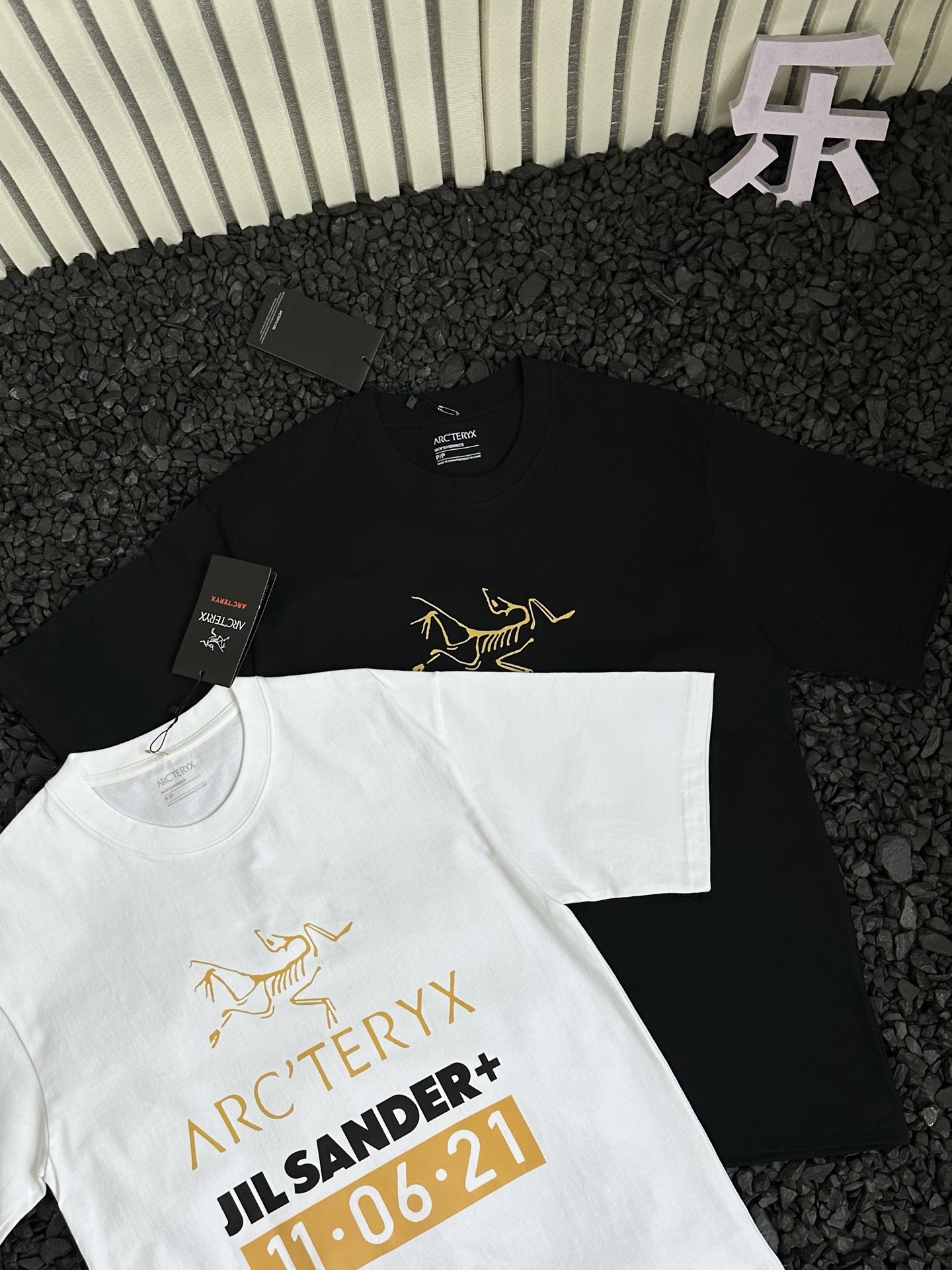 🛒购物价：68💰[原标包装吊牌.采用200克纯棉面料]广东本地工厂直销.另外有240克需加10元. 鸟屎110621短袖

- Arcteryx 始祖鸟 夏季新款纯色设计感logo字母涂鸦印花潮流高街时尚美式运动休闲短袖T恤 情侣款 -


      轻薄透气抗皱免烫，适宜春夏穿着的一款服饰，采用高品质轻薄面料，搭配透气设计，散热十分出色，带来干爽舒适的夏日。
面料选用100%原厂！纯棉透气舒适又吸湿，手感柔软亲肤，平滑的触感富有弹性，吸汗性与排湿性都绝佳，胸前logo字母涂鸦印花细节体现匠心品质！ 
袖口和下摆处的压胶工艺，是细节之处的极致追求。它不仅让服装外观更显精致，更有效减少了摩擦，为你带来细腻亲肤的穿着体验。
实用百搭打底款式！纯色T恤是每个潮人衣柜里的必备单品！是品质与时尚的完美融合，是你不可或缺的时尚挚友！不挑身材，穿着自在无拘！穿上它，开启精致生活，每一刻都是时尚大片。
胸前logo字母涂鸦印花，简约中彰显品牌个性，辨识度超高，瞬间提升时尚度。采用德国进口数码印机所以印花是超清晰的！穿久了也不会裂！
领口设计合理，贴合颈部曲线，穿着舒适且不易变形！
版型宽阔舒适，穿在身上自然的贴合在肌肤上，经典不变，舒适百搭可塑性极强的一款单品！
宽松休闲的版型包容性强，男女同款，不同身材都能驾驭，还自带慵懒时髦感！所有细节均为原相机实拍，放心入手！


颜色：黑色 白色 
尺码：如下