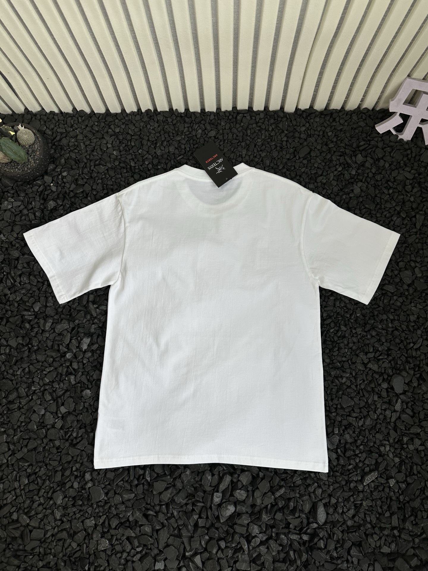 🛒购物价：68💰[原标包装吊牌.采用200克纯棉面料]广东本地工厂直销.另外有240克需加10元. 鸟屎110621短袖

- Arcteryx 始祖鸟 夏季新款纯色设计感logo字母涂鸦印花潮流高街时尚美式运动休闲短袖T恤 情侣款 -


      轻薄透气抗皱免烫，适宜春夏穿着的一款服饰，采用高品质轻薄面料，搭配透气设计，散热十分出色，带来干爽舒适的夏日。
面料选用100%原厂！纯棉透气舒适又吸湿，手感柔软亲肤，平滑的触感富有弹性，吸汗性与排湿性都绝佳，胸前logo字母涂鸦印花细节体现匠心品质！ 
袖口和下摆处的压胶工艺，是细节之处的极致追求。它不仅让服装外观更显精致，更有效减少了摩擦，为你带来细腻亲肤的穿着体验。
实用百搭打底款式！纯色T恤是每个潮人衣柜里的必备单品！是品质与时尚的完美融合，是你不可或缺的时尚挚友！不挑身材，穿着自在无拘！穿上它，开启精致生活，每一刻都是时尚大片。
胸前logo字母涂鸦印花，简约中彰显品牌个性，辨识度超高，瞬间提升时尚度。采用德国进口数码印机所以印花是超清晰的！穿久了也不会裂！
领口设计合理，贴合颈部曲线，穿着舒适且不易变形！
版型宽阔舒适，穿在身上自然的贴合在肌肤上，经典不变，舒适百搭可塑性极强的一款单品！
宽松休闲的版型包容性强，男女同款，不同身材都能驾驭，还自带慵懒时髦感！所有细节均为原相机实拍，放心入手！


颜色：黑色 白色 
尺码：如下