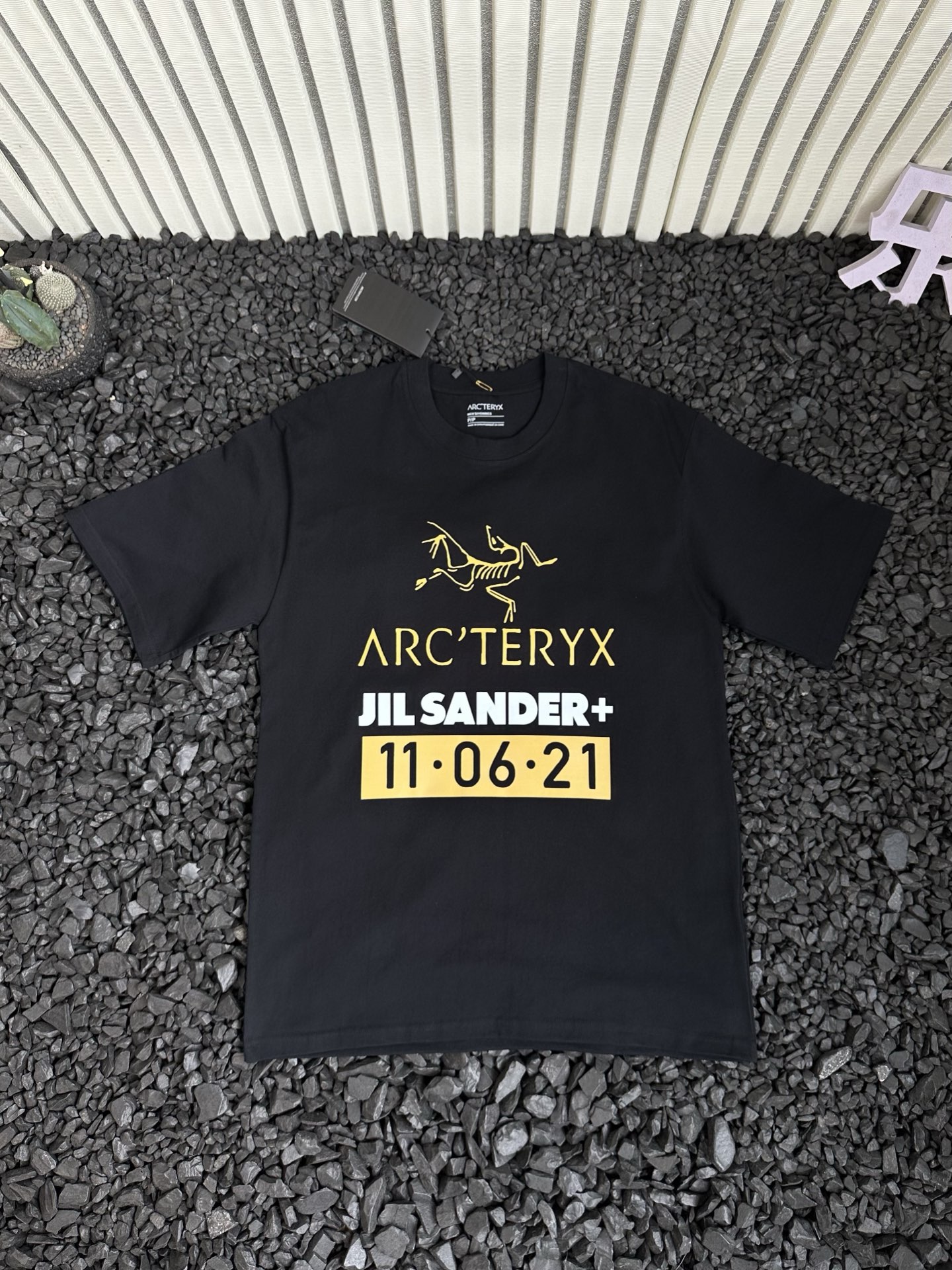 🛒购物价：68💰[原标包装吊牌.采用200克纯棉面料]广东本地工厂直销.另外有240克需加10元. 鸟屎110621短袖

- Arcteryx 始祖鸟 夏季新款纯色设计感logo字母涂鸦印花潮流高街时尚美式运动休闲短袖T恤 情侣款 -


      轻薄透气抗皱免烫，适宜春夏穿着的一款服饰，采用高品质轻薄面料，搭配透气设计，散热十分出色，带来干爽舒适的夏日。
面料选用100%原厂！纯棉透气舒适又吸湿，手感柔软亲肤，平滑的触感富有弹性，吸汗性与排湿性都绝佳，胸前logo字母涂鸦印花细节体现匠心品质！ 
袖口和下摆处的压胶工艺，是细节之处的极致追求。它不仅让服装外观更显精致，更有效减少了摩擦，为你带来细腻亲肤的穿着体验。
实用百搭打底款式！纯色T恤是每个潮人衣柜里的必备单品！是品质与时尚的完美融合，是你不可或缺的时尚挚友！不挑身材，穿着自在无拘！穿上它，开启精致生活，每一刻都是时尚大片。
胸前logo字母涂鸦印花，简约中彰显品牌个性，辨识度超高，瞬间提升时尚度。采用德国进口数码印机所以印花是超清晰的！穿久了也不会裂！
领口设计合理，贴合颈部曲线，穿着舒适且不易变形！
版型宽阔舒适，穿在身上自然的贴合在肌肤上，经典不变，舒适百搭可塑性极强的一款单品！
宽松休闲的版型包容性强，男女同款，不同身材都能驾驭，还自带慵懒时髦感！所有细节均为原相机实拍，放心入手！


颜色：黑色 白色 
尺码：如下