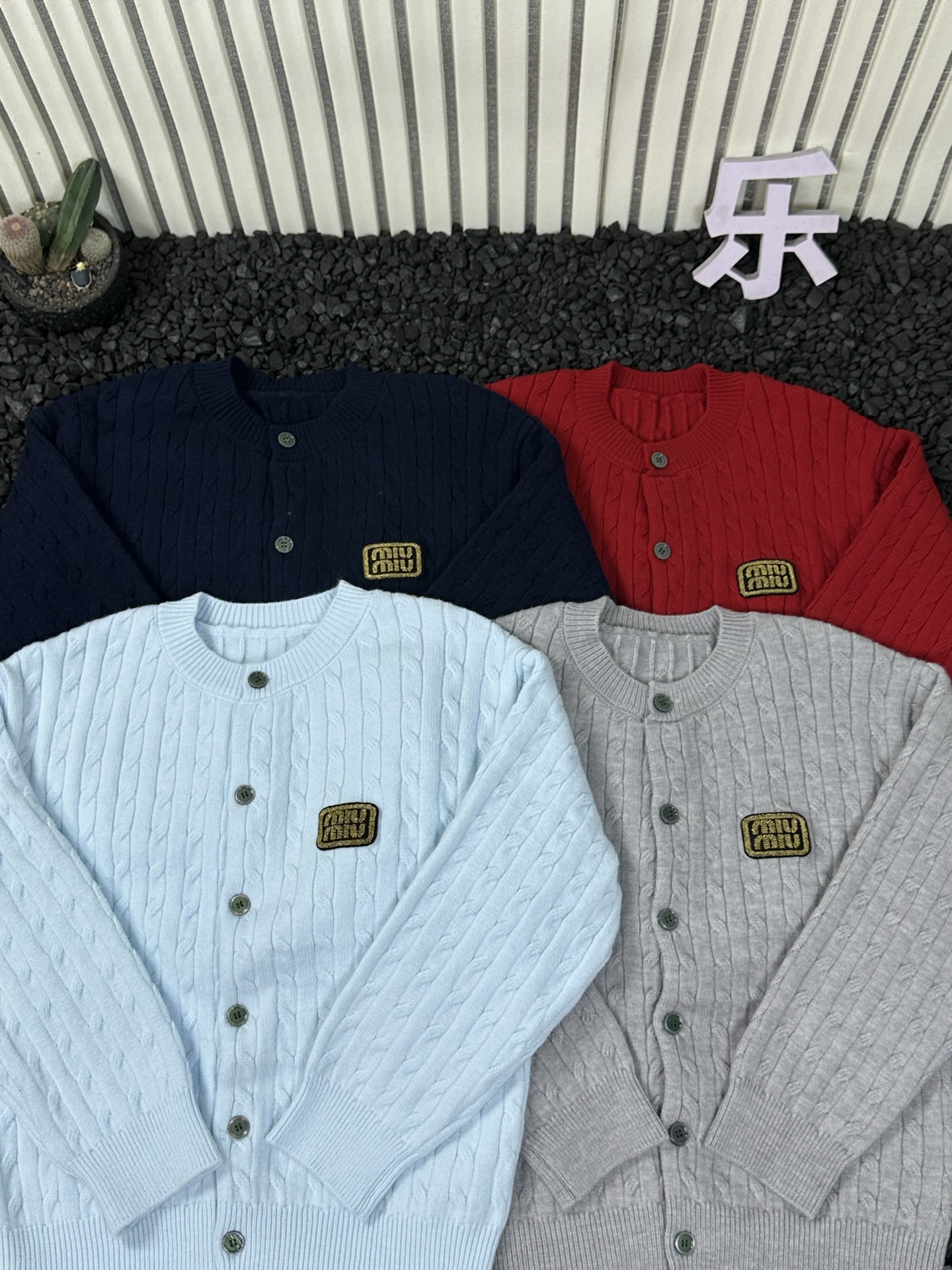 💰135  
- MIUMIU缪缪 25ss秋冬新品女士坑条半拉链毛衣温柔系氛围感单品 -

   精选软糯混纺面料，亲肤不扎身，坑条肌理自带慵懒松弛感，圆领纽扣开衫领口设计既能修饰脖颈线条又方便穿脱，胸前标志性miu系小标低调彰显质感！
四色齐发都是不挑人的高级色系，日常搭配牛仔裤、西装裤或半裙都能轻松出片，不管是通勤还是休闲约会都适配，版型宽松不臃肿，藏肉显瘦同时还能叠穿内搭，这个冬天用一件温柔毛衣锁住温暖与时髦，喜欢的宝子别犹豫，早穿早美~

颜色：黑色 藏青色 天蓝色 红色
尺码：M-3XL
       衣长  胸围   袖长  建议体重  
M    60     50     70     100-120
L      62     52     71     120-140
XL    64    54     72      140-160
XXL  66   56     73       160-180
3XL  68   68     74       180-200