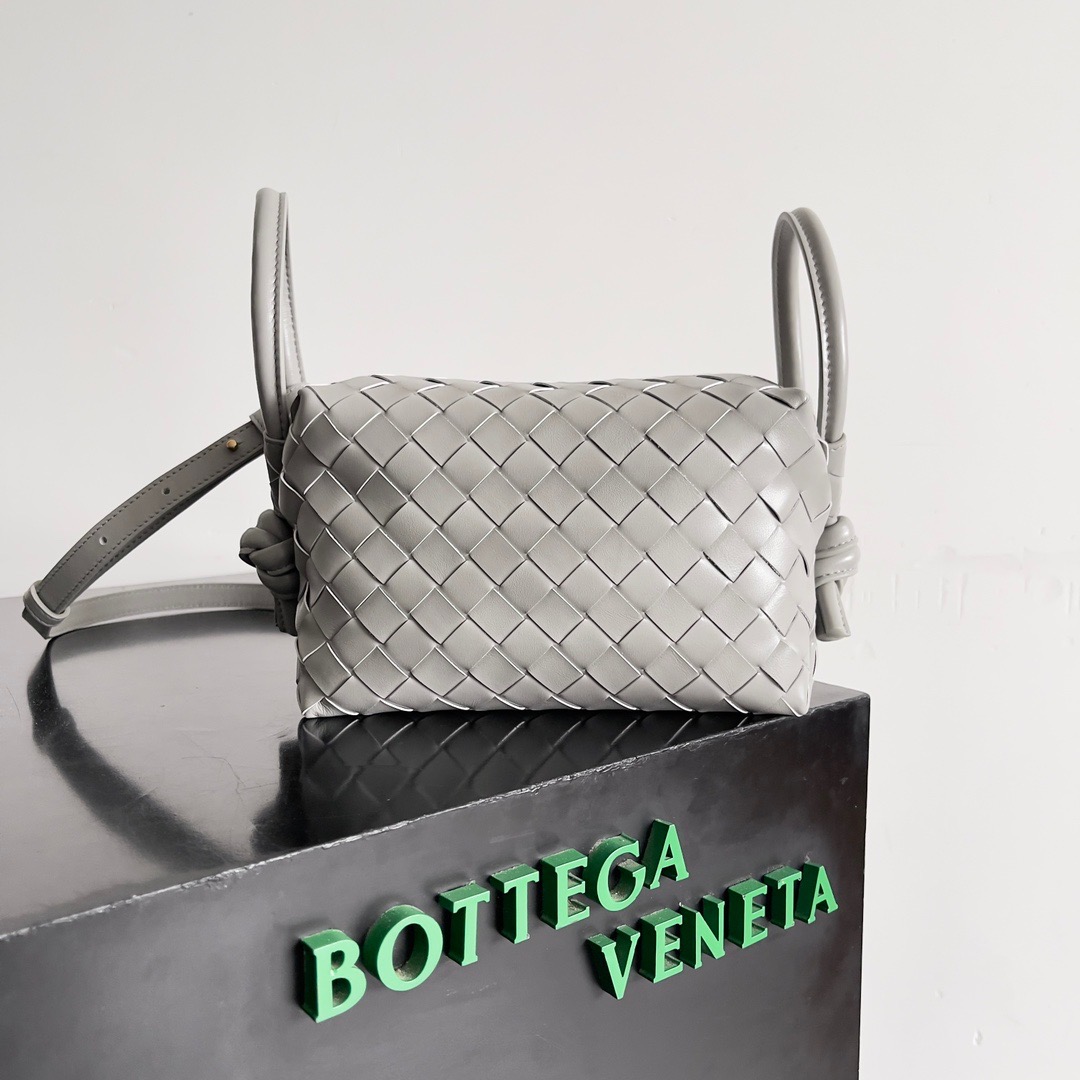 BOTTEGA VENETA 新款loop来啦！！喜欢bv家的女孩子很多都拥有过loop这一款包包吧，简约的外观，经典的编织，小巧轻便的包型，这一次的创新延续了“相机包”的造型，不同于传统loop只能斜挎包，这次创新之后可以手提，也可以斜挎，对凹造型和日常需求双向满足，超大的环扣可将手袋折叠使用，也可作为手柄，夏天的闷热通常会降低人们的欲望，有一款轻便的包包会大大提升出行的幸福感\n款号：\n尺寸：cm