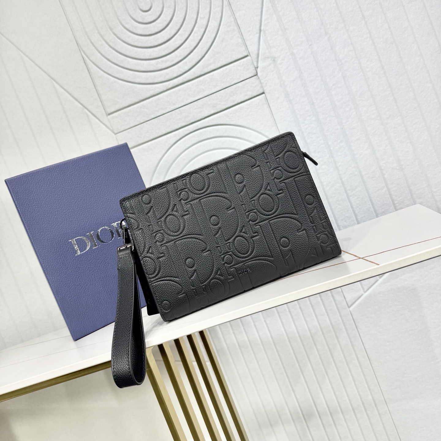 440💰市场最高版本（原单品质）正品打版

【保证全头层进口牛皮，拒绝二层皮，拒绝超纤皮】
«配盒子/礼品袋»

A5 三角形手拿包
黑色 Dior Gravity 印花效果皮革
编号: 2ESCA483LLG_H00N
这款手拿包是 Dior 的主打单品。Dior Gravity 印花效果皮革采用压花工艺将经典图案精致呈现于黑色牛皮革之上，正面饰以 Dior 标志，充分彰显 Dior 工坊的精湛工艺。宽敞的拉链隔层适合收纳手机，还设有六个卡槽。搭配可拆卸的粒面牛皮革腕带，可手提或放入手袋中。
主体：牛皮革
里料：科技面料，棉，牛皮革
拉链主隔层
内部插袋
6 个粒面牛皮革卡槽
可拆卸粒面牛皮革腕带
正面饰以金属覆层铜合金 Dior 标志
内部饰有 Dior 压花标志
内含防尘袋
尺寸：27 x 19 x 6.5 厘米（长 x 高 x 宽）
主隔层可收纳各类手机