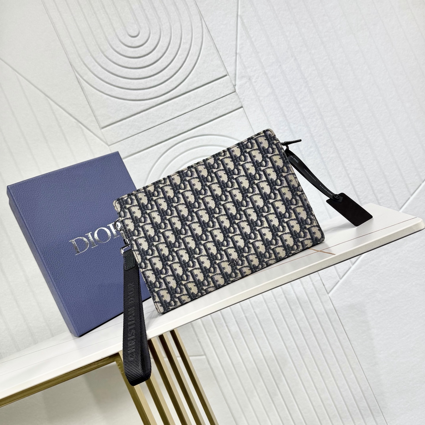 400💰市场最高版本（原单品质）正品打版

【保证全头层进口牛皮，拒绝二层皮，拒绝超纤皮】
«配盒子/礼品袋»

A5 三角形手拿包
米色和黑色 Oblique 印花面料
编号: 2ESCA483YKY_H27E
这款手拿包是 Dior 的主打单品。采用米色和黑色 Oblique 印花面料等材质精心制作，从 Dior 档案汲取灵感，正面饰以 Dior 标志提升格调。宽敞的拉链隔层适合收纳手机，还设有六个卡槽。搭配可拆卸的尼龙提花腕带，可手提或放入手袋中。
主体：棉，科技面料，牛皮革
里料：科技面料，棉，牛皮革
拉链主隔层
内部插袋
6 个粒面牛皮革卡槽
可拆卸的 Christian Dior 标志尼龙提花腕带
正面饰以金属覆层铜合金 Dior 标志
内部饰有 Dior 压花标志
内含防尘袋
尺寸：27 x 19 x 6.5 厘米（长 x 高 x 宽）
主隔层可收纳各类手机