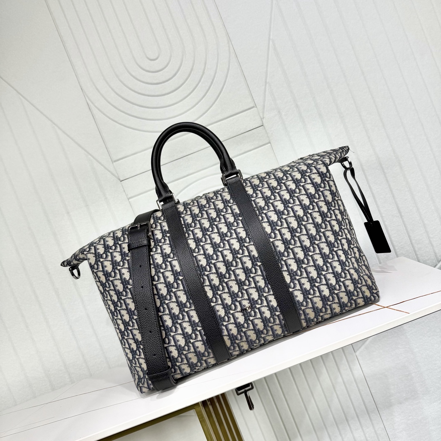 720💰市场最高版本（原单品质）正品打版

【保证进口头层牛皮，拒绝二层皮，拒绝超纤皮】

Weekender 40 手袋
米色和黑色 Oblique 印花面料和黑色粒面牛皮革
编号: 1ESDU134YKY_H27E
这款 Weekender 40 手袋彰显经久不衰的高雅风格。采用米色和黑色 Oblique 印花面料等材质精心制作，全新演绎经典的 Dior 图案，饰以黑色粒面牛皮革细节和正面的 Dior 标志提升格调。设有宽大的拉链主隔层，可收纳各种周末假日的用品。搭配可调节、可拆卸的肩带和顶部皮革手柄，可手提或肩背。
主体：棉，牛皮革，科技面料
里料：科技面料，棉，牛皮革
拉链主隔层
内部拉链口袋
顶部皮革手柄
可调节、可拆卸的皮革肩带搭配龙虾扣
保护性金属垫脚
正面饰以金属覆层铜合金 Dior 标志
内部饰有 Dior 压花标志
内含防尘袋
意大利制造
尺寸：58 x 33 x 22.5 厘米（长 x 高 x 宽）
肩带长度：87 - 115.5 厘米
肩带顶端至手袋顶端长度：32 - 49 厘米
顶部手柄长度：32 厘米
手柄顶端至手袋顶端长度：9 厘米