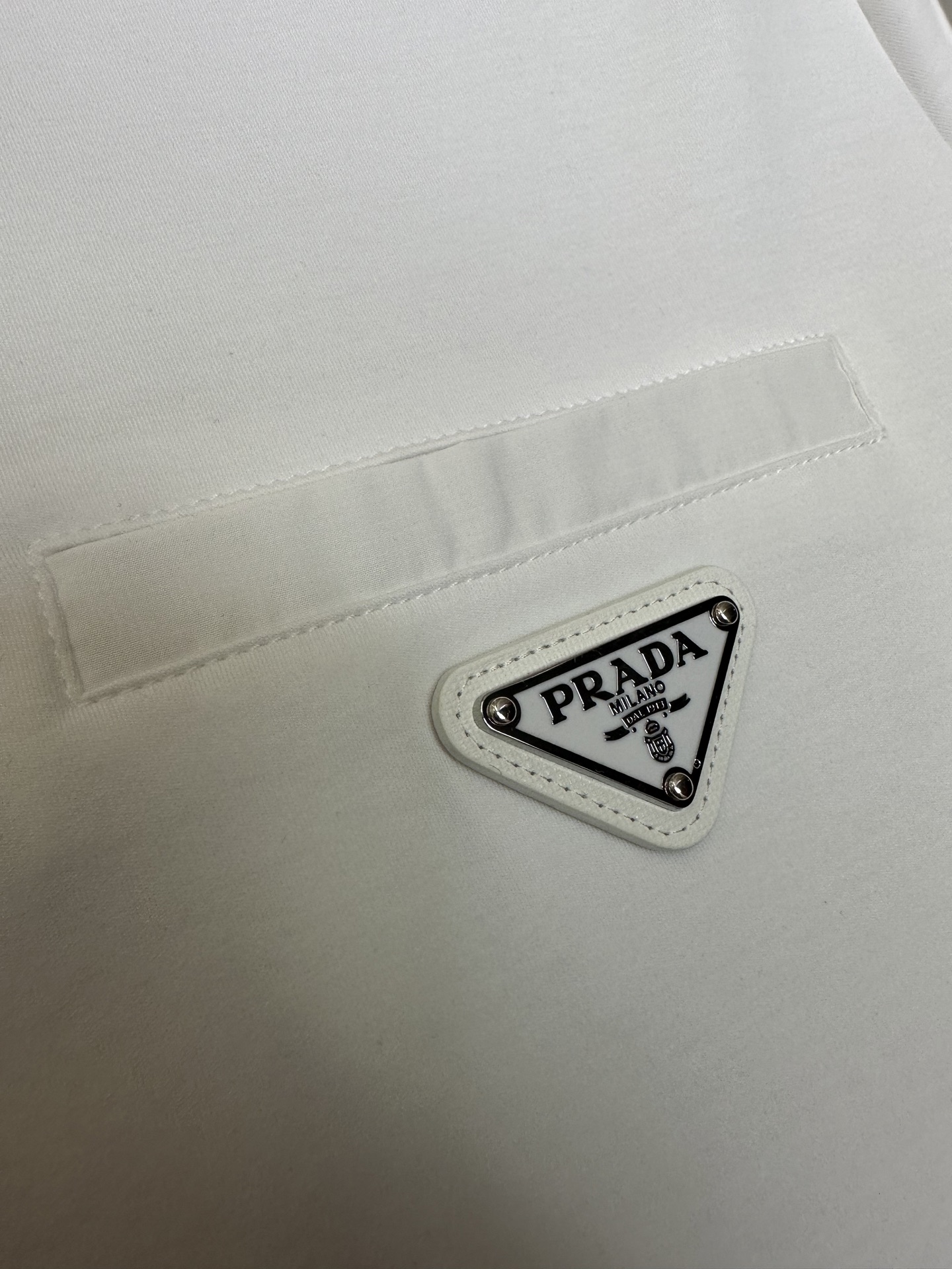 Prada26春夏新品液氨T恤 Prada这款基础款T恤秉承品牌低调简约的理念，经典的针梭织拼接设计，肩