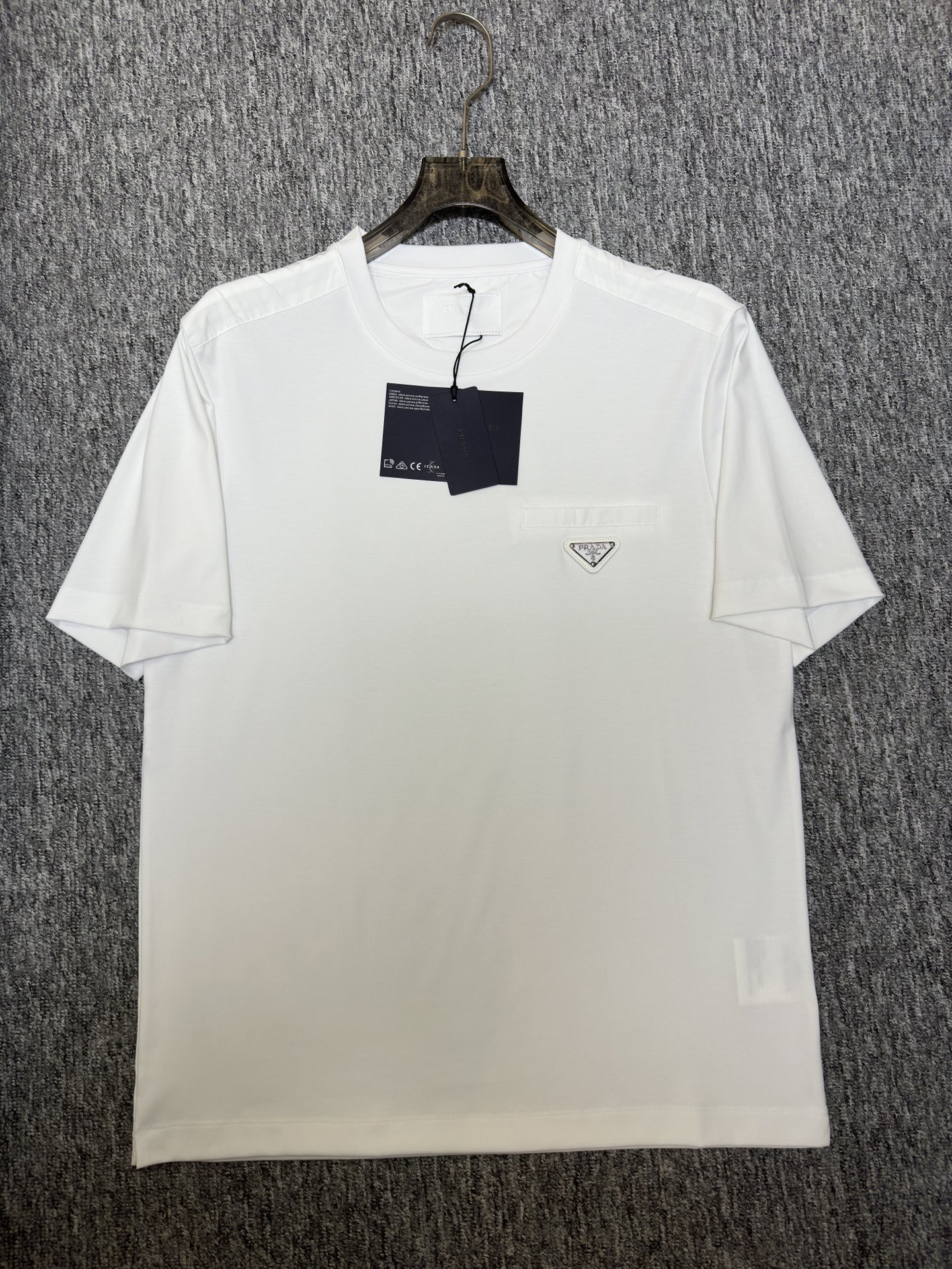 Prada26春夏新品液氨T恤 Prada这款基础款T恤秉承品牌低调简约的理念，经典的针梭织拼接设计，肩