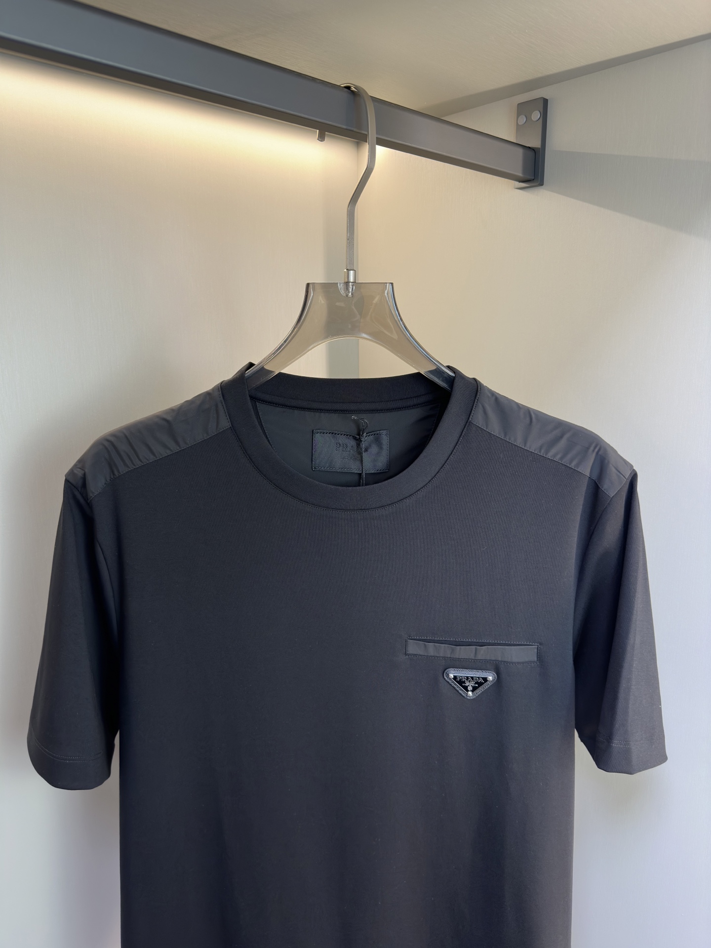Prada26春夏新品液氨T恤 Prada这款基础款T恤秉承品牌低调简约的理念，经典的针梭织拼接设计，肩