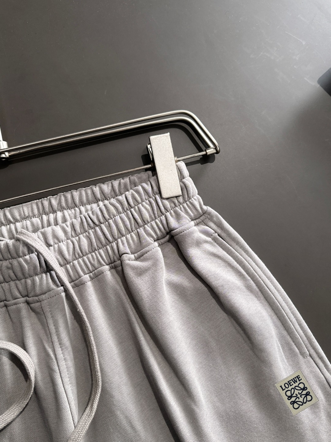 隔天出货 P225  LOEWE/罗意威 高品质 2025春夏新款松紧带休闲重工水洗套装，蜡染牛肚吸汗透气，专柜定制面料 透气舒适度高，细节无可挑剔，品牌元素设计理念，体现高品质。手感细腻柔软！呈现休闲裁剪，上身版型超赞！贸易公司渠道稀出，同步官网发售！来自男士高端定位品牌，高段位，低调奢华的品味，让人无法拒绝！做工精美、品相无法挑剔！整体风格简约时尚不过时，完全满足了有格调品味的穿搭要求！
尺码：S-XXL