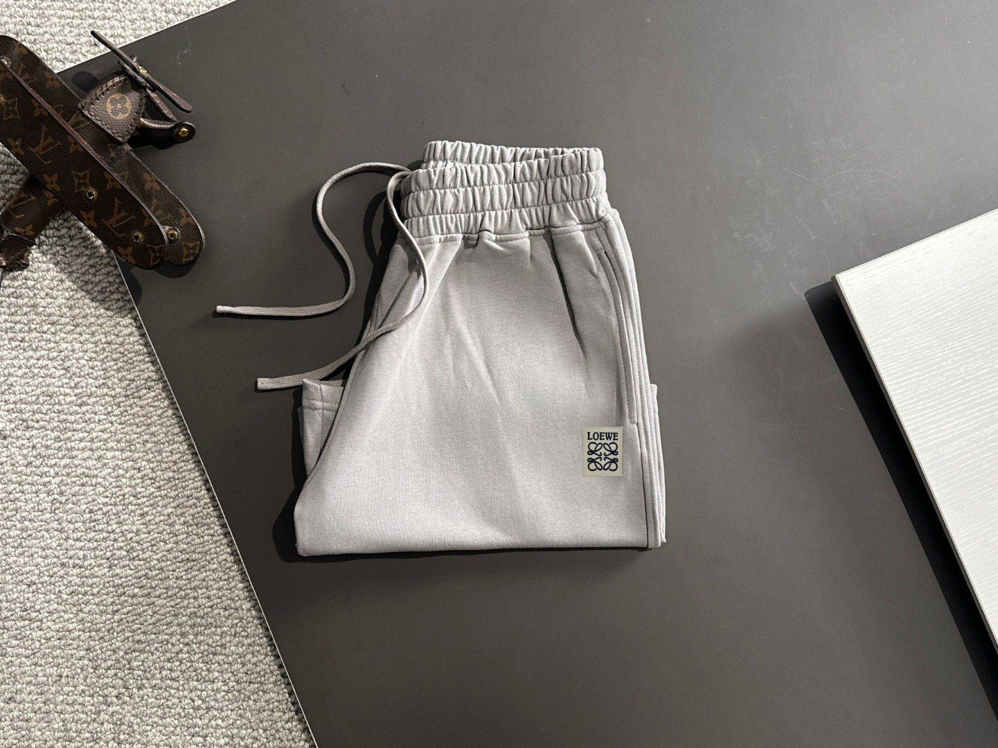 隔天出货 P225  LOEWE/罗意威 高品质 2025春夏新款松紧带休闲重工水洗套装，蜡染牛肚吸汗透气，专柜定制面料 透气舒适度高，细节无可挑剔，品牌元素设计理念，体现高品质。手感细腻柔软！呈现休闲裁剪，上身版型超赞！贸易公司渠道稀出，同步官网发售！来自男士高端定位品牌，高段位，低调奢华的品味，让人无法拒绝！做工精美、品相无法挑剔！整体风格简约时尚不过时，完全满足了有格调品味的穿搭要求！
尺码：S-XXL