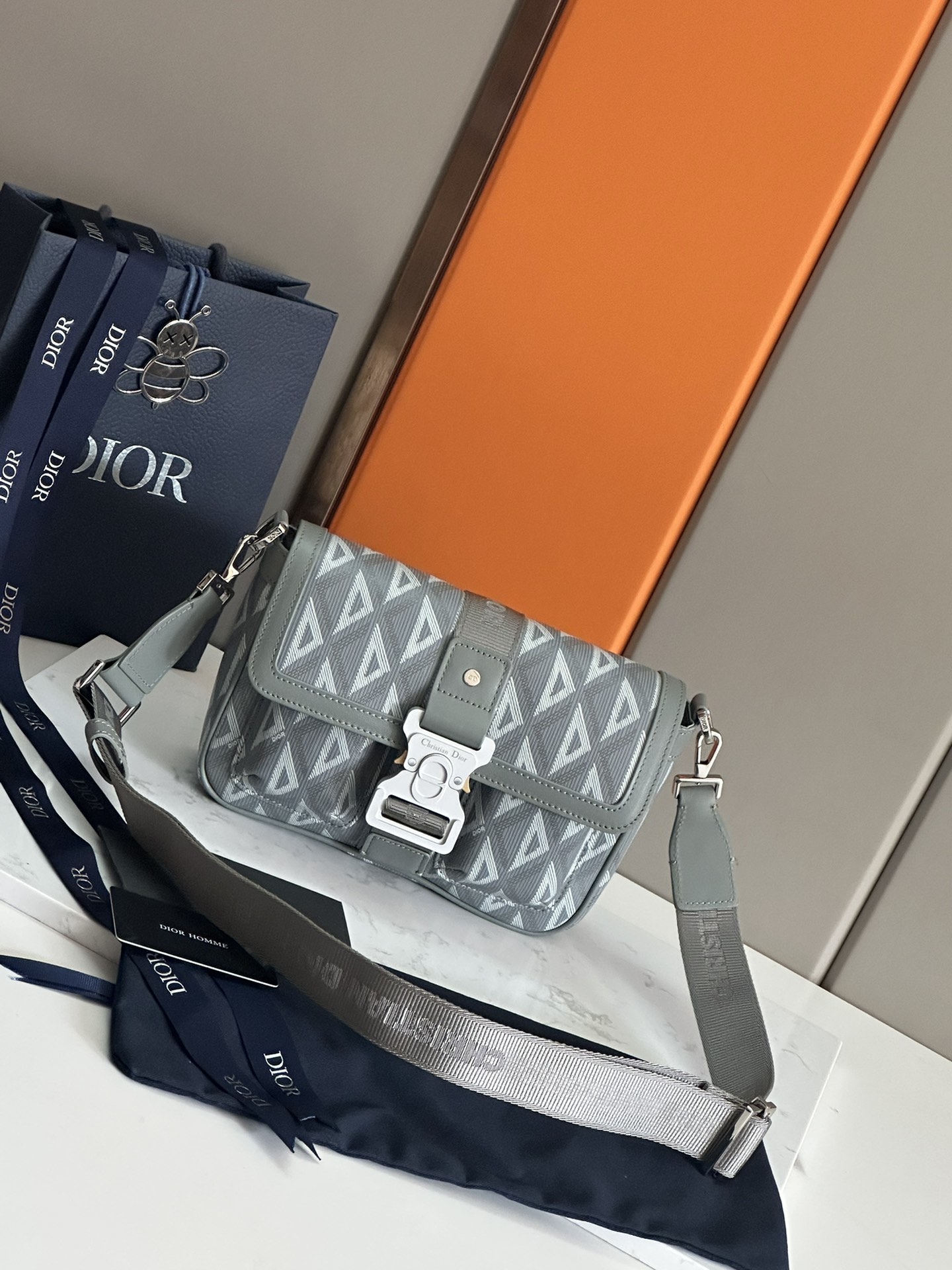 NO:213439,50 Top Original List This Dior Hit the Road handbag is a new product this season, integrating modern style with Dior's high-order spirit. It is carefully crafted in gray CD Diamond pattern canvas and smooth cowhide leather, with a flip with Christian Dior aluminum buckle, spacious main compartment and double pockets on the front, allowing easy storage of everyday items. The style is practical and matched with adjustable and removable shoulder straps, which adds the finishing touch to a variety of casual outfits. Gray Canvas CD Diamond pattern designed by Marc Bohan in 1974 reinterprets the CD initials in three-dimensional line diamond patterns, presented in canvas fabric gray smooth cowhide leather  Dior embossed logo on the inside Flip closure, paired with aluminium buckle with Christian Dior logo and CD initials Adjustable, removable Christian Dior nylon jacquard strap No.: 1ESME 93380 Black canvas Gray canvas Leather Dimensions 27 x 17 x 9 cm (L x H x W) Main compartment can accommodate two iPhone 13 Pro Max phones and an iPad Mini, Dior, Dior, Cowhide1986090950 顶级原单 这款 Dior Hit the Road 手袋搭配肩带,是本季新品,将现代风格与 Dior 的高订精神融为一体.采用灰色 CD Diamond 图案帆布和光滑牛皮革精心制作,翻盖搭配 Christian Dior 铝扣,宽敞的主隔层和正面双口袋设计,可轻松收纳各种日常用品.款式实用,搭配可调节、可拆卸的肩带,可为各式休闲装扮增添点睛之笔. 灰色帆布 CD Diamond 图案 马克·博昂 (Marc Bohan) 于 1974 年设计的 CD Diamond 图案以立体线条菱形图案重新诠释 CD 首字母,呈现于帆布面料 灰色光滑牛皮革 内侧饰有 Dior 压花标志 翻盖开合,搭配饰以Christian Dior标志和 CD 首字母的铝扣 可调节、可拆卸的 Christian Dior 尼龙提花肩带 编号: 1ESME 93380 黑帆布 灰帆布 会皮 尺寸27 x 17 x 9 厘米（长 x 高 x 宽） 主隔层可容纳两部 iPhone 13 Pro Max 手机和一台 iPad Mini,迪奥,dior,dior,cowhide,Bag