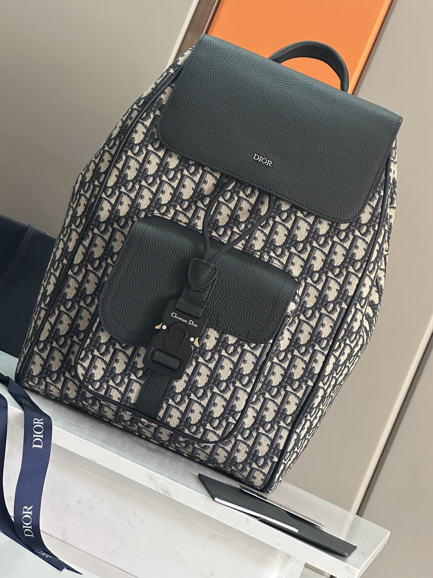 NO:213351,This saddle backpack is a new product for men's fall 2024. It uses a stylish original design to highlight the saddle style. It is carefully crafted from beige and black Oblique printed fabrics, decorated with black grained cowhide leather details, and the front is embellished with Dior logo. It is spacious and has a compartment to hold a variety of daily necessities. The front saddle flip pocket is paired with aluminum buckles, which can hold a wallet, keys, headphones or mobile phones for easy access. It is practical and versatile and is the finishing touch of all kinds of styling. The main compartment is paired with magnetic flip cover and drawstring. The interior laptop flat compartment Front saddle flip pocket is paired with CD logo aluminum buckle Leather top handle Adjustable padded shoulder straps Back with padded mesh fabric adorned with Dior logo Metal cladding on the front Dior logo Dior logo Inside with Dior embossed logo on the inside  Dust bags included Made in Italy Size 26.5 x 41 x 14 cm (L x H x W) Main compartment can hold 1 15-inch laptop, files and 1 tablet Weight 961 g Model 93392 Blue cloth Black cloth Full leather, Dior, Dior, Dior, Wallets, backpacks, cowhide19860909这款马鞍双肩背包是二零二四秋季男装系列新品,采用时尚的原创设计,突显马鞍风格.采用米色和黑色 Oblique 印花面料精心制作,饰以黑色粒面牛皮革细节,正面点缀以 Dior 标志.空间宽敞,设有一个隔层,可收纳各种日常用品,正面马鞍翻盖口袋搭配铝扣,可收纳钱包、钥匙、耳机或手机,便于轻松取用.实用百搭,是各式造型的点睛之笔. 主隔层搭配磁性翻盖和抽绳 内部笔记本电脑扁平隔层 正面马鞍翻盖口袋搭配 CD 标志铝扣 皮革顶部手柄 可调节加垫肩带 背部采用加垫网眼织物,饰以 Dior 标志 正面金属覆层黄铜 Dior 标志 内侧饰有 Dior 压花标志 内含防尘袋 意大利制造尺寸26.5 x 41 x 14 厘米（长 x 高 x 宽） 主隔层可收纳 1 台 15 英寸笔记本电脑、文件和 1 台平板电脑 重量961 克 型号93392蓝布 黑布 全皮,迪奥,dior,dior,wallets,backpacks,cowhide,Bag