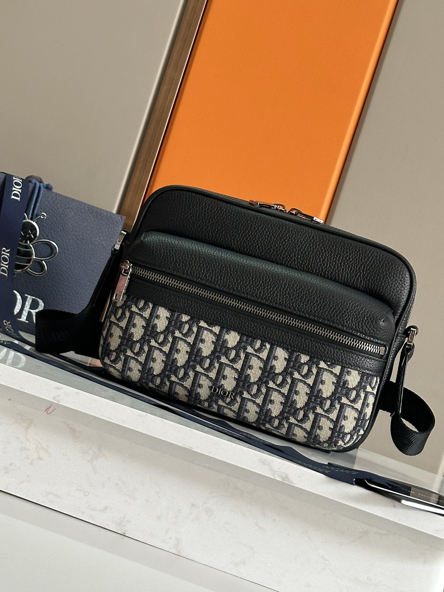 NO:395077,This Rider 2.0 Zipper Messenger Bag is a new product for men's fall 2024. It is practical and exquisite, and is an ideal item for daily life. Dior Gravity printed leather uses embossing craftsmanship to present classic patterns on khaki cowhide leather. The front is decorated with tonal grain cowhide details and Dior logo, fully demonstrating the exquisite craftsmanship of Dior Workshop. Zipper compartments and front pockets can hold various personal items, paired with adjustable straps, can be shoulder or crossbody. Nylon interior Zipper main compartment Front zipper pocket Internal insert pocket Back pocket Adjustable Christian Dior logo nylon jacquard and cowhide shoulder strap Front metal cladding brass Dior logo Inside embossed with Dior embossed logo Inside dust bag Number:  1ESPO3 leather blue cloth black cloth 93397 size 23 x 17 x 7.5 cm, Dior, dior, dior, cowhide19860909这款 Rider 2.0 拉链式信使包是二零二四秋季男装系列新品,实用而精巧,是日常生活的理想单品.Dior Gravity 印花效果皮革采用压花工艺将经典图案精致地呈现于卡其色牛皮革之上,正面饰以同色调粒面牛皮革细节和 Dior 标志,充分彰显 Dior 工坊的精湛工艺.拉链隔层和正面口袋可收纳各种个人用品,搭配可调节带,可肩背或斜挎. 尼龙内部 拉链主隔层 正面拉链口袋 内部插袋 背面插袋 可调节的 Christian Dior 标志尼龙提花和牛皮革肩带 正面金属覆层黄铜 Dior 标志 内侧饰以 Dior 压花标志 内含防尘袋 编号: 1ESPO3皮蓝布 黑布93397 尺寸23 x 17 x 7.5 厘米,迪奥,dior,dior,cowhide,Bag