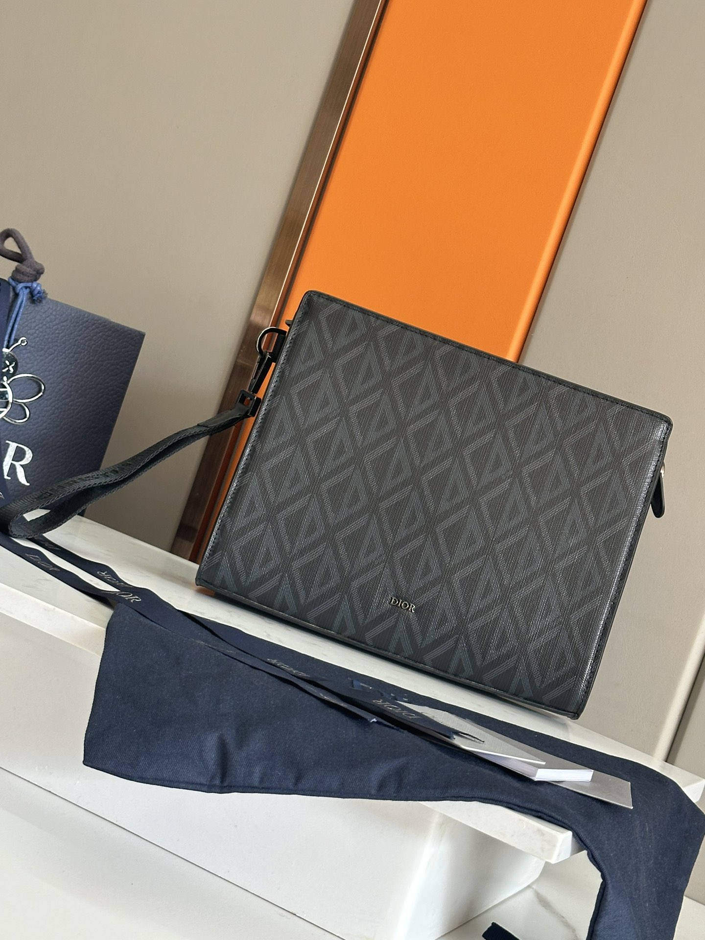 NO:213357,Top A5 clutch black Oblique print No.: 2ESCA483YKY_H03E Size 27×19.5×6 cm (Length×H×W) This clutch is the main item of Dior. It is carefully crafted from the black Oblique print jacquard fabric, drawing inspiration from the Dior archives, and the front is decorated with a Dior logo to enhance the style. It has a wide zipper compartment that can hold the phone, and there are six card slots. It is paired with a removable grained cowhide wristband, which can be carried or put into the handbag. The interior is made of smooth cowhide inner insert bag 6 grained cowhide slots Removable grained cowhide wristband with lobster buckle metal cladding brass Dior logo on the inside is decorated with Dior embossed logo containing dust bags, Dior, dior, handbag, cowhide19860909顶级 A5 手拿包黑色 Oblique 印花 编号:2ESCA483YKY_H03E 尺寸27×19.5×6厘米（长×高×宽） 这款手拿包是Dior的主打单品.采用黑色Oblique 印花提花面料精心制作,从Dior档案汲取灵感,正面饰以Dior 标志提升格调.设有一个可收纳手机的宽大拉链隔层,还有六个卡槽.搭配可拆卸的粒面牛皮革腕带,可手提或放入手袋中. 内部采用光滑牛皮革内部插袋 6个粒面牛皮革卡槽 可拆卸粒面牛皮革腕带搭配龙虾扣正面金属覆层黄铜Dior标志内侧饰以 Dior压花标志内含防尘袋,迪奥,dior,dior,handbag,cowhide,Bag