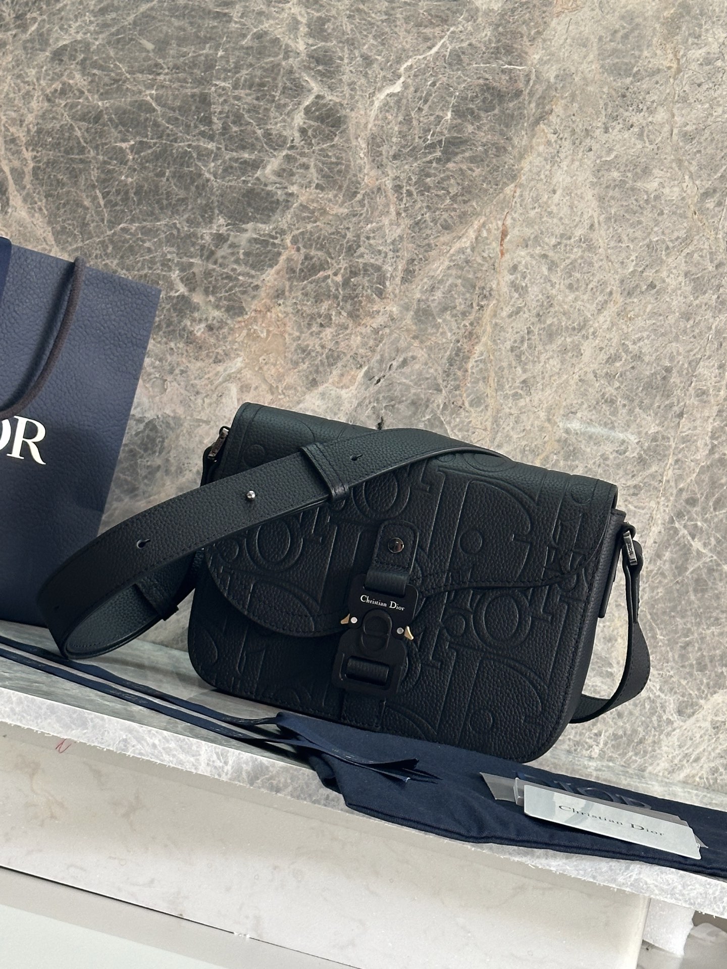 NO:386353,P Top Original List This saddle messenger bag is a new product this season, exquisite and stylish. It is carefully crafted from black grain cowhide leather, decorated with a contrasting noodle thread, paired with a flap that highlights the saddle style aesthetics, and is embellished with an aluminum buckle to enhance the style. The mini style is spacious inside, with a patch pocket that makes it more refined and can store a variety of daily necessities, paired with adjustable leather and CHRISTIAN DIOR logo jacquard straps, which can be worn on the shoulder or crossbody. The black grain cowhide with sharp noodle thread is decorated with DIOR embossed inside Adjustable leather and leather shoulder straps CHRISTIAN DIOR logo shoulder straps Flip closure Aluminum buckle is decorated with Christian Dior logo and CD initials Internal patch pockets Included dust bag Size 23 x 18 x 6 cm Can hold various models  iPhone number 93362 full leather embossed, Dior, Dior, Cowhide19860909P 顶级原单 这款马鞍信使包是本季新品,精巧时尚.采用黑色粒面牛皮革精心制作,饰以对比鲜明的缉面线,搭配彰显马鞍风格审美的翻盖,点缀以铝扣提升格调.迷你款式,内部空间宽敞,设有一个贴袋更显精致,可收纳各种日常用品,搭配可调节的皮革和CHRISTIAN DIOR标志提花肩带,可肩背或斜挎. 黑色粒面牛皮革搭配对比鲜明的缉面线 内部饰以DIOR压花标志 可调节的皮革和皮肩带CHRISTIAN DIOR标志肩带 翻盖开合 铝扣饰以Christian Dior标志和CD首字母 内部贴袋 内含防尘袋 尺寸23 x 18 x 6 厘米 可收纳各种型号的 iPhone 编号93362全皮压花,迪奥,dior,dior,cowhide,Bag