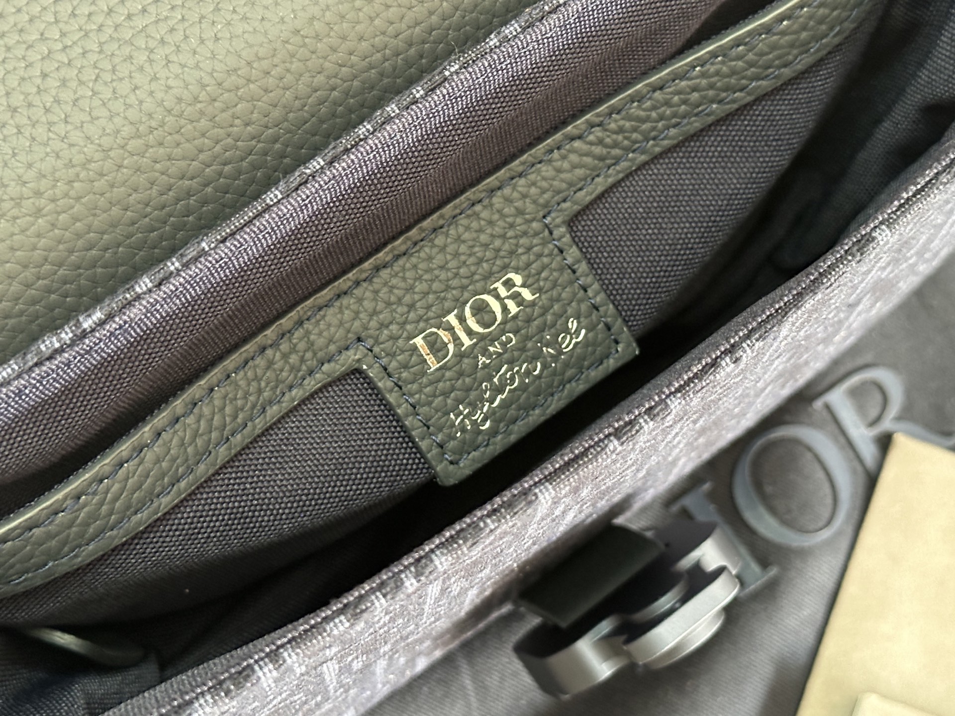   这款马鞍手拿包附有肩带，是二零二五春季男装系列推出的新款单品，采用时尚的设计，彰显精致的优雅气质，为