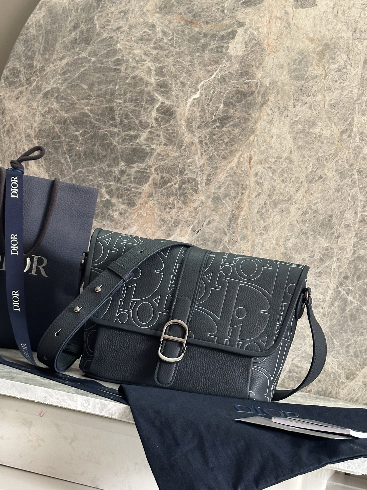 NO:395112,P Medium Dior Daily Flip Messenger Bag Number: 1ESPO376LLG_93925 This Dior Daily Flip Messenger Bag is a new product in the autumn men's clothing series of 2025, showing an elegant and practical design. The Dior Gravity printed leather uses embossing technology to present classic patterns on black cowhide leather, highlighting the exquisite craftsmanship of Dior Workshop. The flip is decorated with a magnetic Dior Daily buckle interpreted from the CD's first letter to enhance the style, with a spacious compartment. The back is equipped with a zippered pocket to make it look more refined. The medium style is paired with adjustable shoulder straps, which can be worn on the shoulder or crossbody, adding a fashionable high-order style to all kinds of outfits. Body cowhide leather Lining technology fabric, cotton, cowhide leather  Main compartment with flap and Dior Daily buckle Internal insert pocket Rear zipper pocket Adjustable leather shoulder strap Internal embossed with Dior embossed logo Included dust bag size 28 x 18 x 9.5 cm (L x H x W) Main compartment 2 mobile phones Strap length 107 - 138 cm Strap top to top of handbag length 47 - 58 cm Dior,dior,dior,cowhide19860909P  中号 Dior Daily 翻盖信使包 编号:1ESPO376LLG_93925 这款 Dior Daily 翻盖信使包是二零二五秋季男装系列新品,展现优雅实用的设计.Dior Gravity 印花效果皮革采用压花工艺将经典图案精致地呈现于黑色牛皮革之上,彰显 Dior 工坊的精湛工艺.翻盖饰以从 CD 首字母演绎而来的磁性 Dior Daily 搭扣提升格调,内设一个宽敞的隔层.后侧设有拉链口袋,更显精致.中号款式,搭配可调节肩带,可肩背或斜挎,为各式装扮增添时尚的高订风范. 主体牛皮革 里料科技面料,棉,牛皮革 主隔层搭配翻盖和 Dior Daily 搭扣 内部插袋 后侧拉链口袋 可调节的皮革肩带 内部饰有 Dior 压花标志 内含防尘袋尺寸28 x 18 x 9.5 厘米（长 x 高 x 宽） 主隔层可收纳 2 部手机 肩带长度107 - 138 厘米 肩带顶端至手袋顶端长度47 - 58 厘米,迪奥,dior,dior,cowhide,Bag