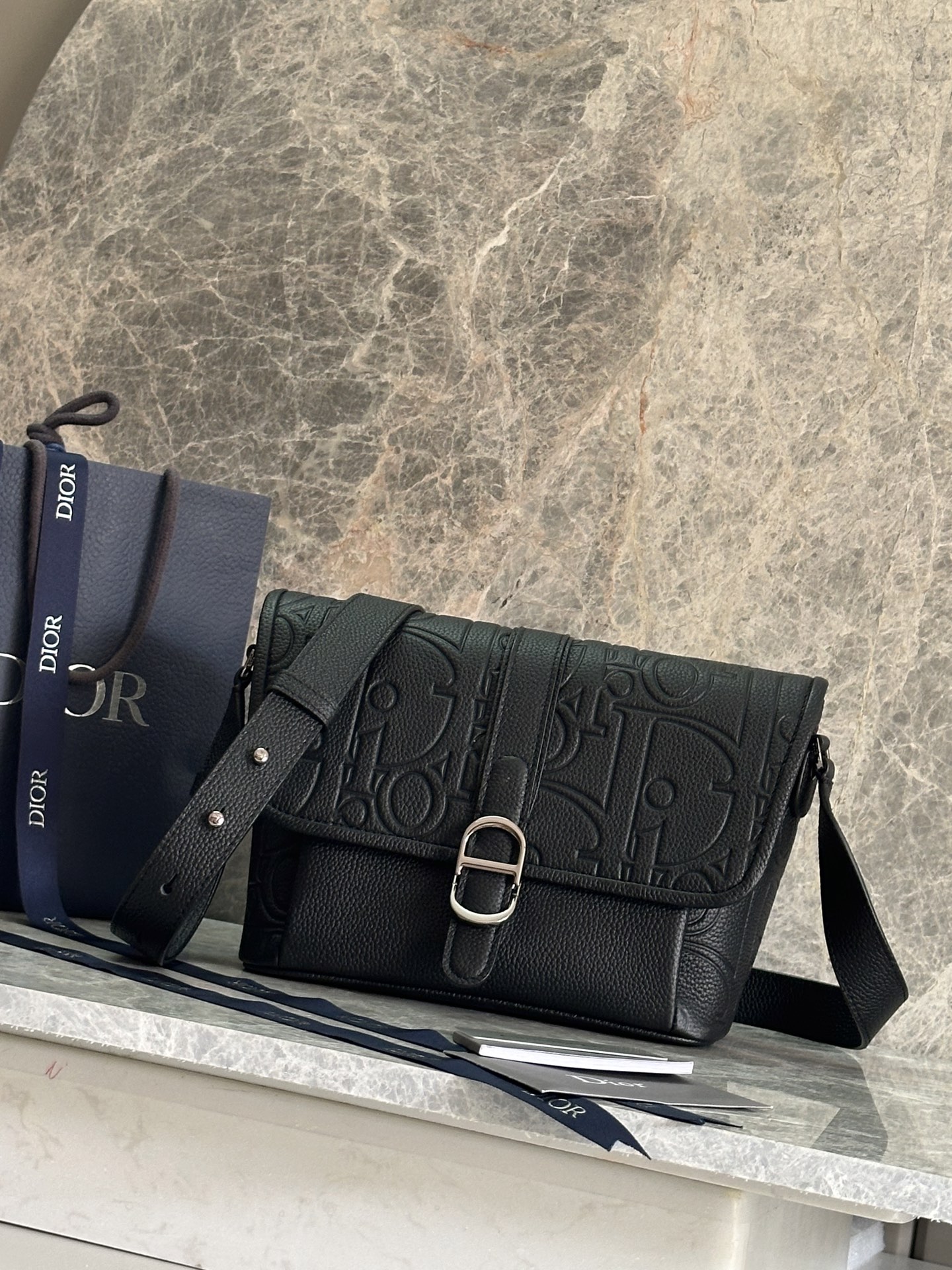 NO:395125,P Medium Dior Daily Flip Messenger Bag Number: 1ESPO376LLG_93925 This Dior Daily Flip Messenger Bag is a new product in the autumn men's clothing series of 2025, showing an elegant and practical design. The Dior Gravity printed leather uses embossing technology to present classic patterns on black cowhide leather, highlighting the exquisite craftsmanship of Dior Workshop. The flip is decorated with a magnetic Dior Daily buckle interpreted from the CD's first letter to enhance the style, with a spacious compartment. The back is equipped with a zippered pocket to make it look more refined. The medium style is paired with adjustable shoulder straps, which can be worn on the shoulder or crossbody, adding a fashionable high-order style to all kinds of outfits. Body cowhide leather Lining technology fabric, cotton, cowhide leather  Main compartment with flap and Dior Daily buckle Internal insert pocket Rear zipper pocket Adjustable leather shoulder strap Internal embossed with Dior embossed logo Included dust bag size 28 x 18 x 9.5 cm (L x H x W) Main compartment 2 mobile phones Strap length 107 - 138 cm Strap top to top of handbag length 47 - 58 cm Dior,dior,dior,cowhide19860909P  中号 Dior Daily 翻盖信使包 编号:1ESPO376LLG_93925 这款 Dior Daily 翻盖信使包是二零二五秋季男装系列新品,展现优雅实用的设计.Dior Gravity 印花效果皮革采用压花工艺将经典图案精致地呈现于黑色牛皮革之上,彰显 Dior 工坊的精湛工艺.翻盖饰以从 CD 首字母演绎而来的磁性 Dior Daily 搭扣提升格调,内设一个宽敞的隔层.后侧设有拉链口袋,更显精致.中号款式,搭配可调节肩带,可肩背或斜挎,为各式装扮增添时尚的高订风范. 主体牛皮革 里料科技面料,棉,牛皮革 主隔层搭配翻盖和 Dior Daily 搭扣 内部插袋 后侧拉链口袋 可调节的皮革肩带 内部饰有 Dior 压花标志 内含防尘袋尺寸28 x 18 x 9.5 厘米（长 x 高 x 宽） 主隔层可收纳 2 部手机 肩带长度107 - 138 厘米 肩带顶端至手袋顶端长度47 - 58 厘米,迪奥,dior,dior,cowhide,Bag