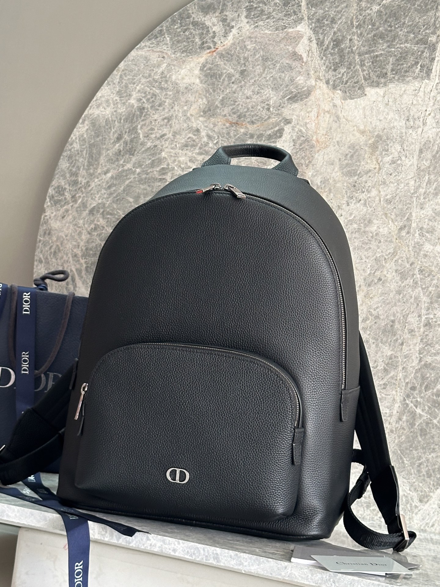 NO:556757,P [Original development.  Top Original] This CD Icon zippered briefcase is a new product in the 2025 winter men's wear series. It has a simple design and showcases Dior's exquisite craftsmanship. It is carefully made of black matte grained cow leather and is decorated with a black metal-clad CD Icon logo on the front. It is paired with a leather luggage tag hanging on a D-shaped ring and embellished with a CD embossed logo to enhance the style. The large zipper compartment has two slip pockets and a zipper pocket. The CD lining is inspired by Dior.  Tailored workmanship. Classic style, with foldable top handle and adjustable, detachable shoulder strap, can be carried by hand, shoulder or cross-body, complementing a variety of items. Main body cowhide leather Lining technical fabrics, cotton, cowhide zippered main compartment 2 slip pockets and 1 internal zippered pocket D-shaped ring for hanging CDs   Embossed leather luggage tag Leather top handle Adjustable, removable leather shoulder strap with lobster clasp and shoulder pad Rear drawbar strap Black metal-clad copper alloy CD icon on front Dior embossed logo on interior Dust bag included Made in Italy Dimensions 31 x 40 x 19 cm (L x H x W) Main compartment can hold 1 15-inch laptop, A4 files and 1 tablet  Model: 93933 black leather, Dior, dior, dior, cowhide19860909P [原版开发．顶级原单] 这款 CD Icon 拉链公文包是二零二五冬季男装系列新品,简约设计,彰显 Dior 精湛工艺.采用黑色哑光粒面牛皮革精心制作,正面饰以黑色金属覆层 CD Icon 标志,搭配悬挂在 D 形饰环上的皮革行李标牌,点缀以 CD 压花标志提升格调.宽大的拉链隔层设有两个插袋和一个拉链口袋,CD 里料灵感源自 Dior 的精裁工艺.款式经典,搭配可折叠顶部手柄和可调节、可拆卸的肩带,可手提、肩背或斜挎,与各式单品相得益彰. 主体牛皮革 里料科技面料,棉,牛皮革 拉链主隔层 2 个插袋和 1 个内部拉链口袋 D 形饰环可悬挂 CD 压花皮革行李标牌 顶部皮革手柄 可调节、可拆卸的皮革肩带搭配龙虾扣和肩垫 后侧拉杆饰带 正面黑色金属覆层铜合金 CD Icon 标志 内部饰有 Dior 压花标志 内含防尘袋 意大利制造 尺寸31 x 40 x 19 厘米（长 x 高 x 宽） 主隔层可收纳 1 部 15 英寸笔记本电脑、A4 文件和 1 部平板电脑 型号:93933黑色皮,迪奥,dior,dior,cowhide,Bag