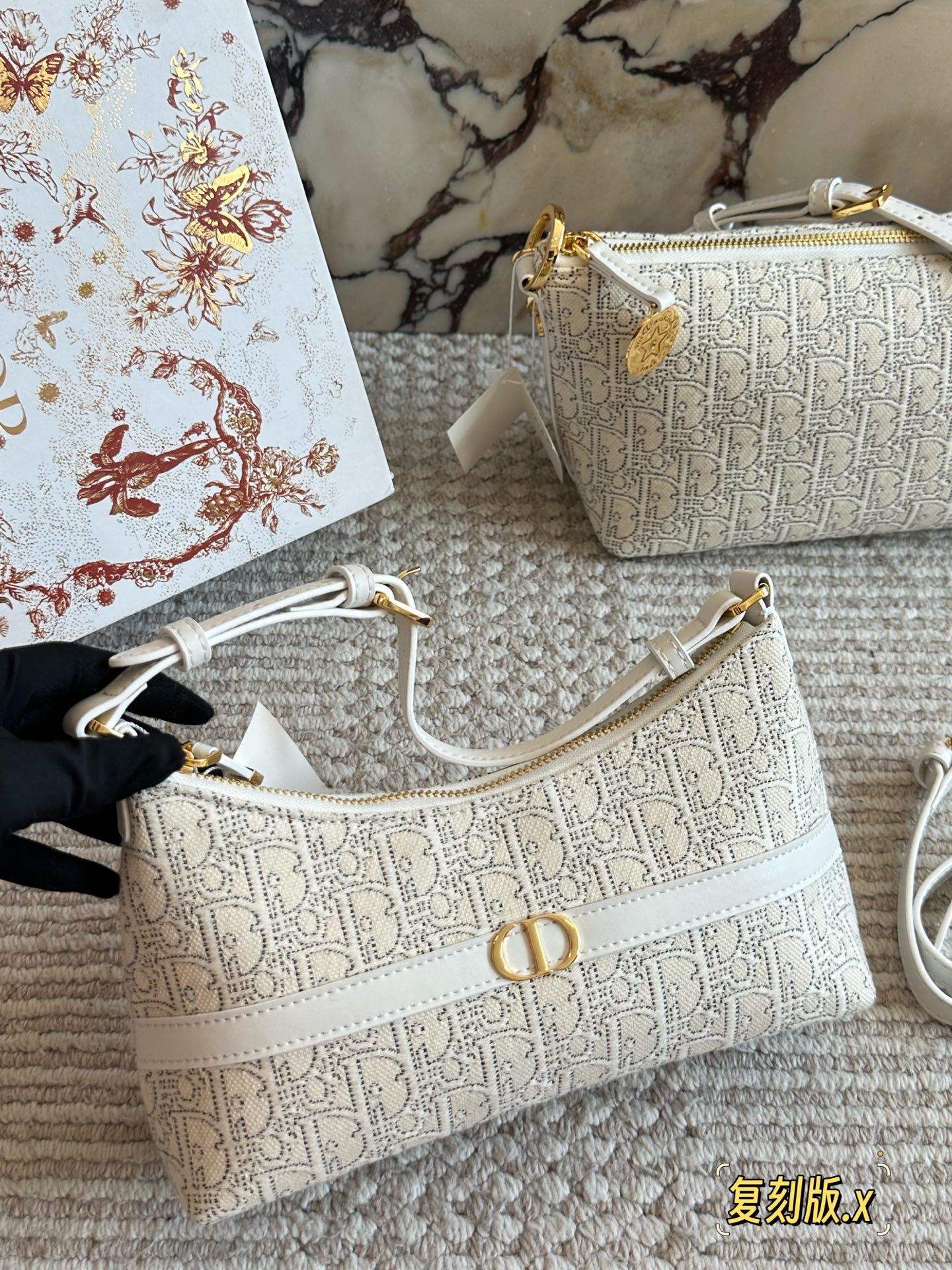 p235 
Dior。上新NEW

白花老花腋下包

这个系列很好看的 给人非常干净的感觉

腋下包，符合小包但同时容量要求不小的要求，自重非常轻，可以做到随走随拎，很方便

同系列护照夹也是极简的设计可以插三张卡24cm