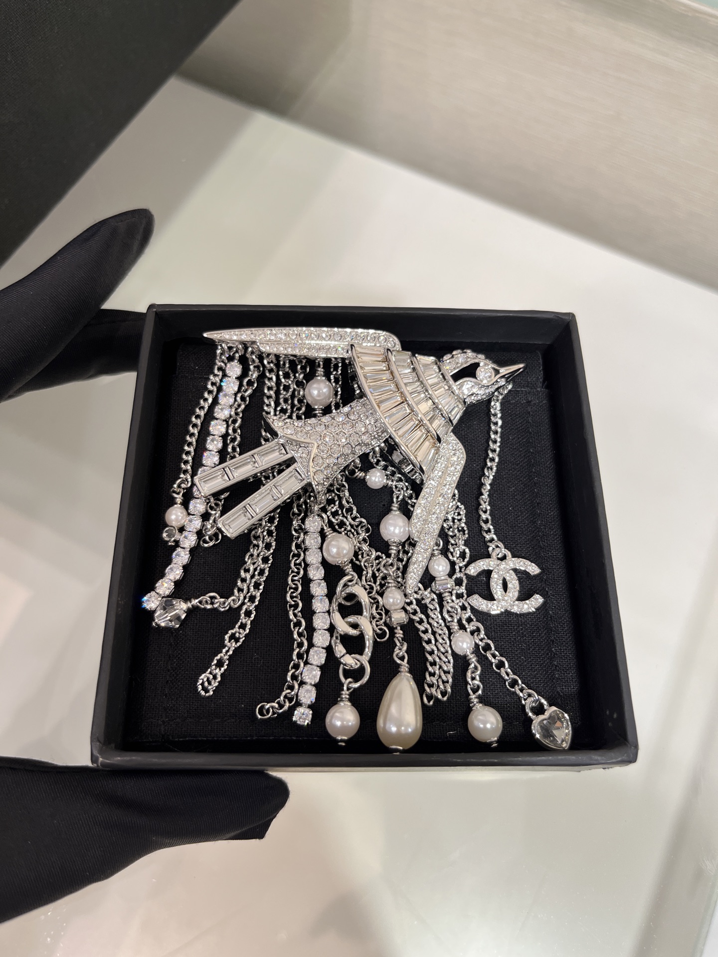 NO:633163,88360, the year's heaviest 25s new silver bird with diamonds and double C pearl chain tassel brooch arrived today. The square diamond bird is so jewelry-like. The tassels are very charming. The year's heaviest is completely a collection-level art. Nature and jewelry art are skillfully integrated. The same brass material as yb. Customized crystal pearls. Enamel craftsmanship. Brooch with packaging box. High beads are visual, brooch, breastpin, Cardia high-end jewelry.1986090988360,今日到货年度最重25s新款银色飞鸟满钻双C珍珠链条流苏胸针 方钻飞鸟太有珠宝感了 流苏美得很有韵味 年度最重完全是收藏级别的艺术品 大自然与珠宝艺术巧妙地融合一体 yb一样黄铜材质 定制水晶珍珠 珐琅工艺 胸针带包装盒 高珠即视感,,brooch，breastpin,卡迪亚高端饰品,Jewelry