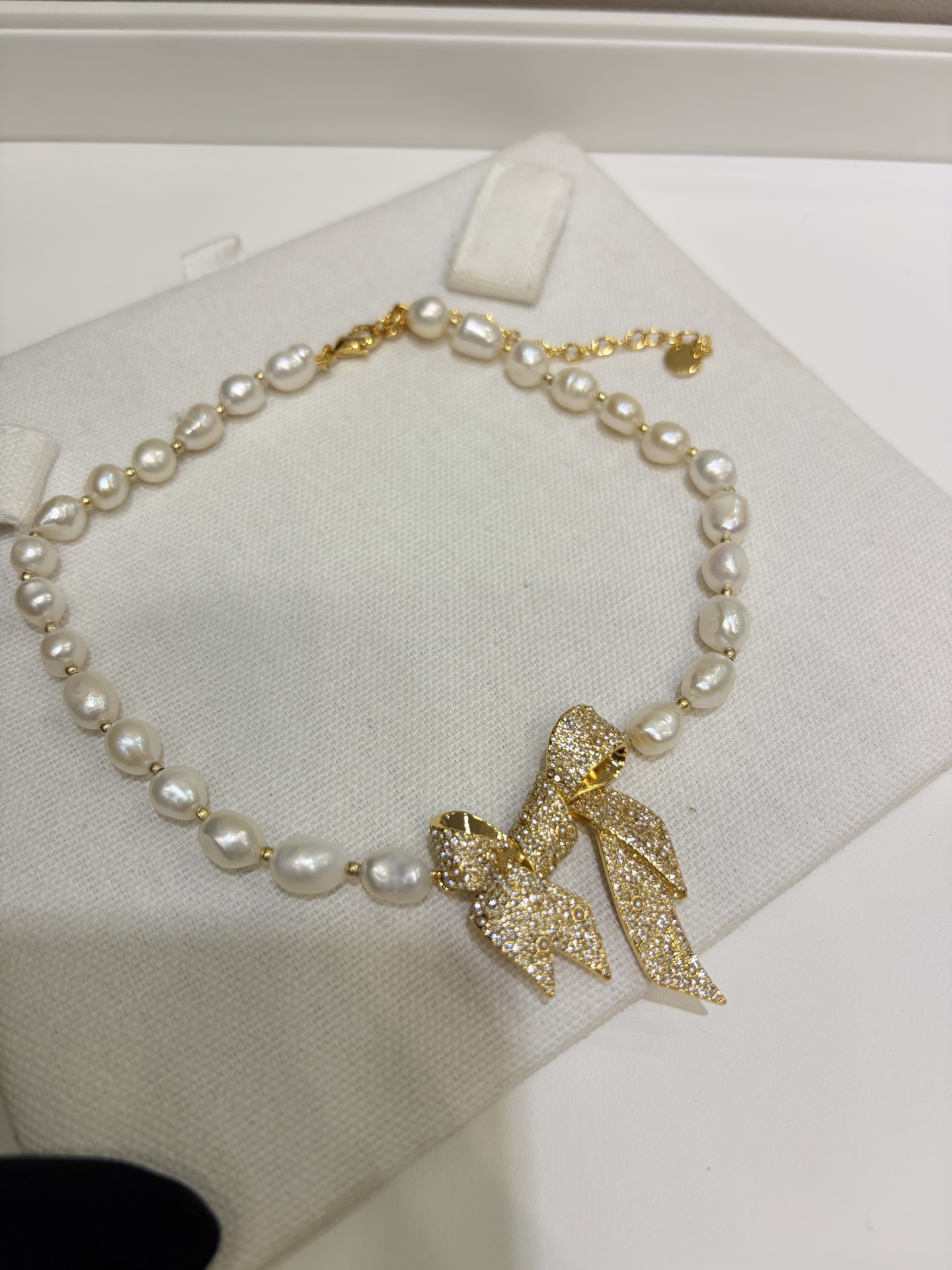 今日新品天然珍珠\n26ss新款金色满钻丝带蝴蝶结巴洛克珍珠项链\n\n丝带蝴蝶结立体造型细节太有质感了\n天然巴洛克珍珠每一颗都是独一无二的\n优雅贵气的法式氛围中又带着野生感生命力\n\nyb一样黄铜材质天然珍珠\n项链带包装盒