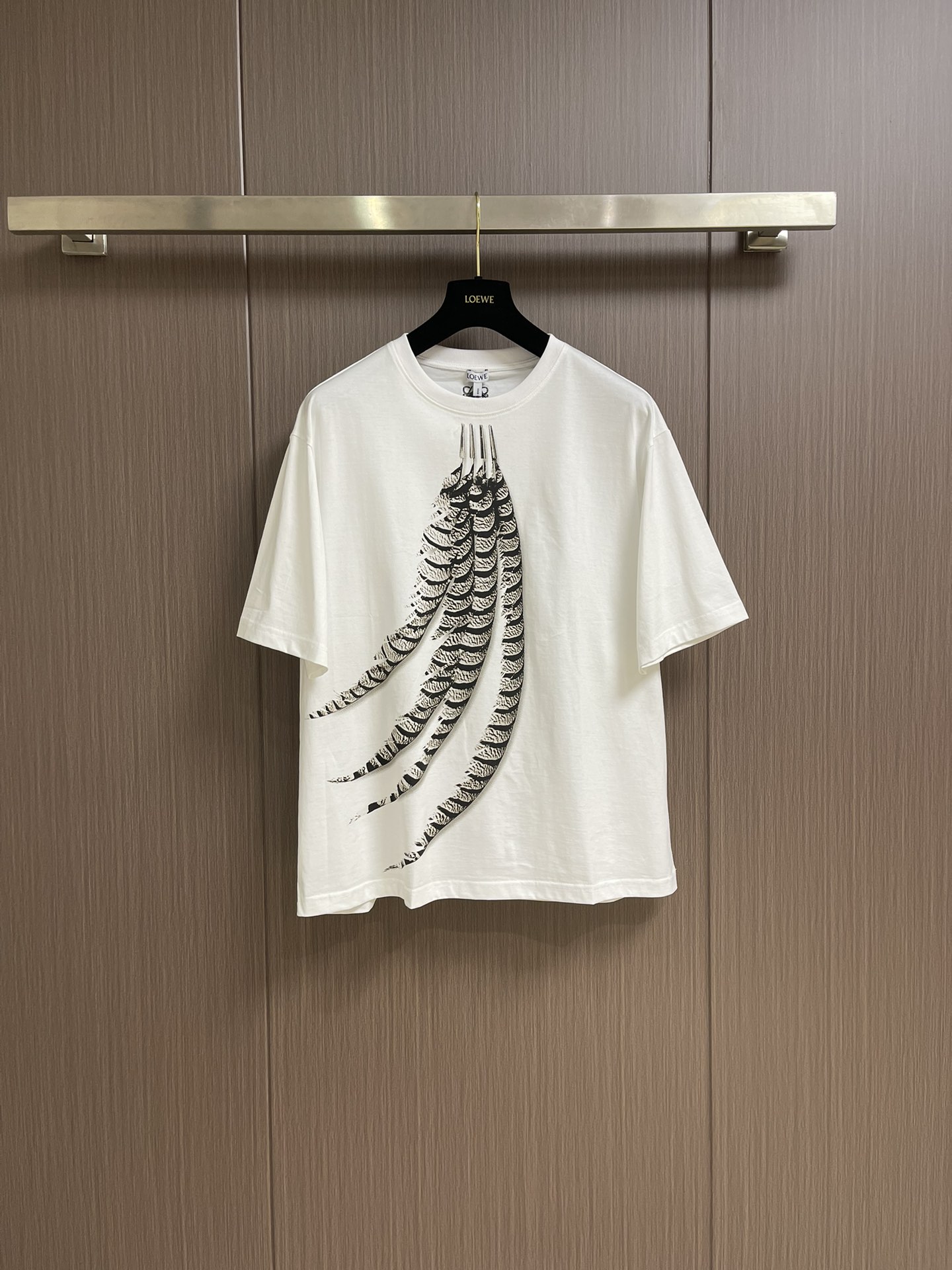 NO:137686,loewe feather printed round neck short-sleeved T-shirt, the fabric is made of 50 mercerated double strands, the fabric is washed with 200 grams, and the thread is matched with 1*1 mercerated Sorona matching thread. The printing adopts digital spraying process, and the computer scans the original pattern and adjusts the color to restore the original effect 1:1. The embroidery uses 3D three-dimensional technology, and this embroidery is matched with the brand's iconic logo under the back collar. The number of needles is 2,600 stitches. Light cotton T-shirt with feather print on the front. Sizes S-M-L,,loewe,loewe,T-shirt,tees,t-shirt,alexander wang19860909loewe 罗意威羽毛印花圆领短袖T恤,面料采用50支丝光双股,面料布匹洗水后克重为200克 螺纹搭配1*1丝光索罗纳配套螺纹.印花采用数码着喷工艺,电脑扫描原版图案后调配色1:1还原原版效果.刺绣采用3d立体工艺,该款刺绣搭配于后幅领下品牌标志性logo.针数为2600针.轻盈棉质t恤,正面饰有羽毛印花.尺码S-M-L,,loewe,loewe,T-shirt,tees，t-shirt,alexander wang,Men's clothing