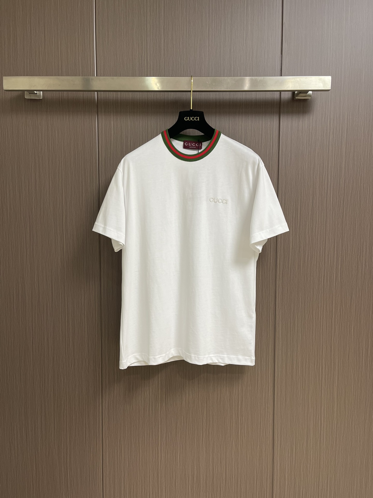 NO:144845,GUCCI 2025ss new neckline with webbing short-sleeved T-shirt, brand elements continue to be renewed, interpreting casual style T-shirts and knitted clothing. This short-sleeved T-shirt is made of lightweight knitted cotton, embellishing gucci logo patches and red and green webbing piping. Pure cotton knitted plain fabric, using 15s fine cotton plain fabric, 230g. Plain wrinkle fabric made of cotton fiber treated with combed process, compared with ordinary cotton fabrics, its fiber arrangement is more neat and dense, so it has better texture and luster. Red and green webbing piping, gucci  Logo embroidery patch, rice-grain needle patch embroidery technology is a traditional hand-made embroidery technique that combines three-dimensional needlework and patch inlay, giving the single product a unique texture and artistic sense. The cuffs and bottom edges are used to fix the edges of the special machine. Size XS-L, gucci, T-shirt, tees, t-shirt, alexander wang19860909GUCCI 2025ss新款 领口饰织带短袖t恤,品牌元素持续焕新,演绎休闲风t恤和针织服饰.这款短袖t恤以轻质针织棉打造,缀饰gucci标识贴饰和红绿织带滚边.纯棉质针织平纹面料,采用15s精棉平纹面料,230g.采用精梳工艺处理的棉纤维制成的平纹织物,相对于普通棉布而言,它的纤维排列更加整齐、密度更高,因此具有更好的质地和光泽.红绿织带滚边,gucci 标识刺绣贴饰,米粒针贴布刺绣工艺是一种结合立体针法与贴布镶嵌的传统手工刺绣技艺,赋予单品独特的肌理感和艺术性.袖口、下摆底边采用的分别专机辑双明线收边固定.尺码XS-L,,gucci,T-shirt,tees，t-shirt,alexander wang,Men's clothing